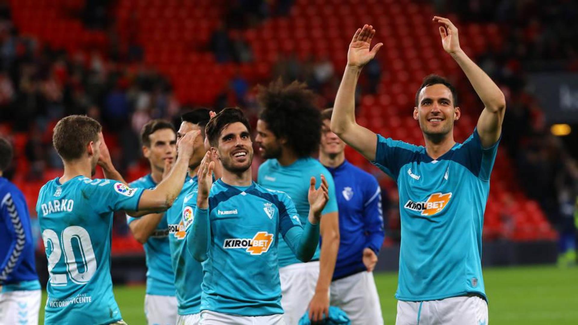 Los jugadores de Osasuna miran a lo alto donde la afición osasunista disfrutaba con el importante triunfo del equipo navarro.