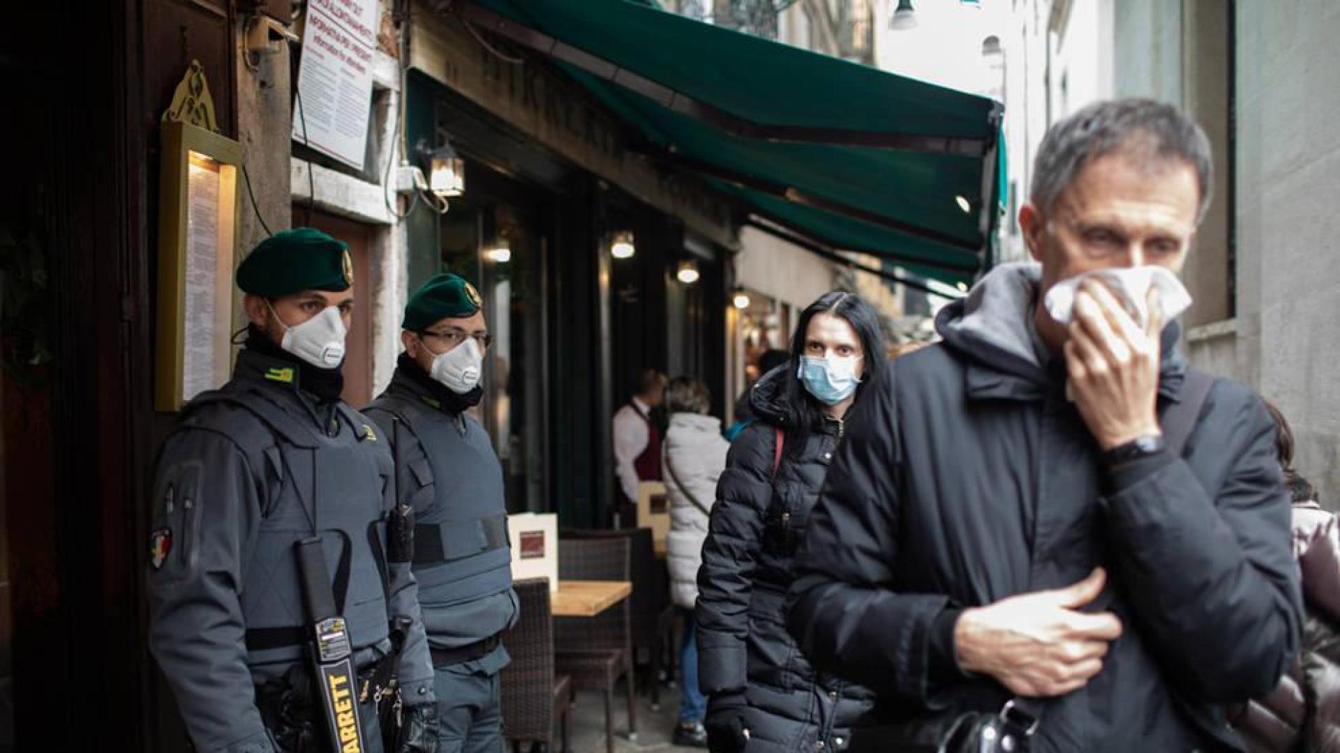 Policías y turistas, con mascarillas, en las calles de Venecia.