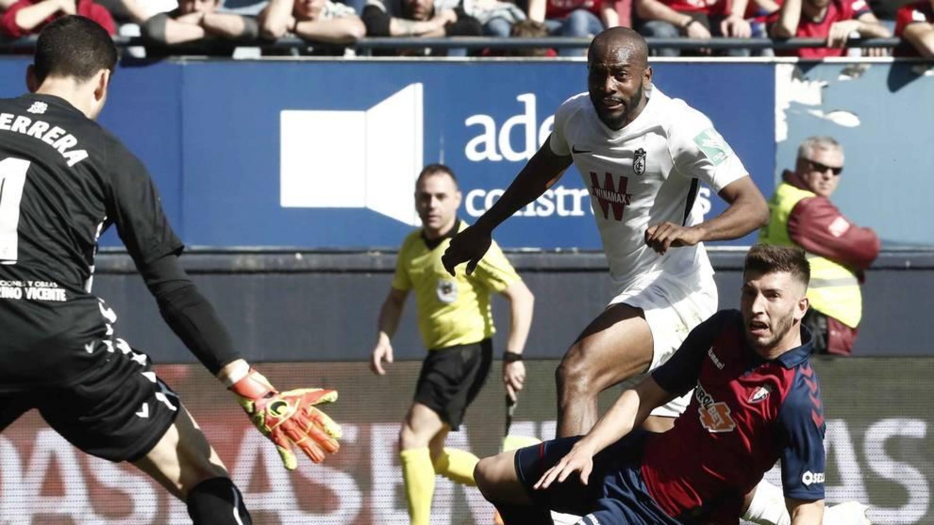 Foulquier y David García siguen el balón con la mirada en el disparo que ha supuesto el tercer gol del Granada.