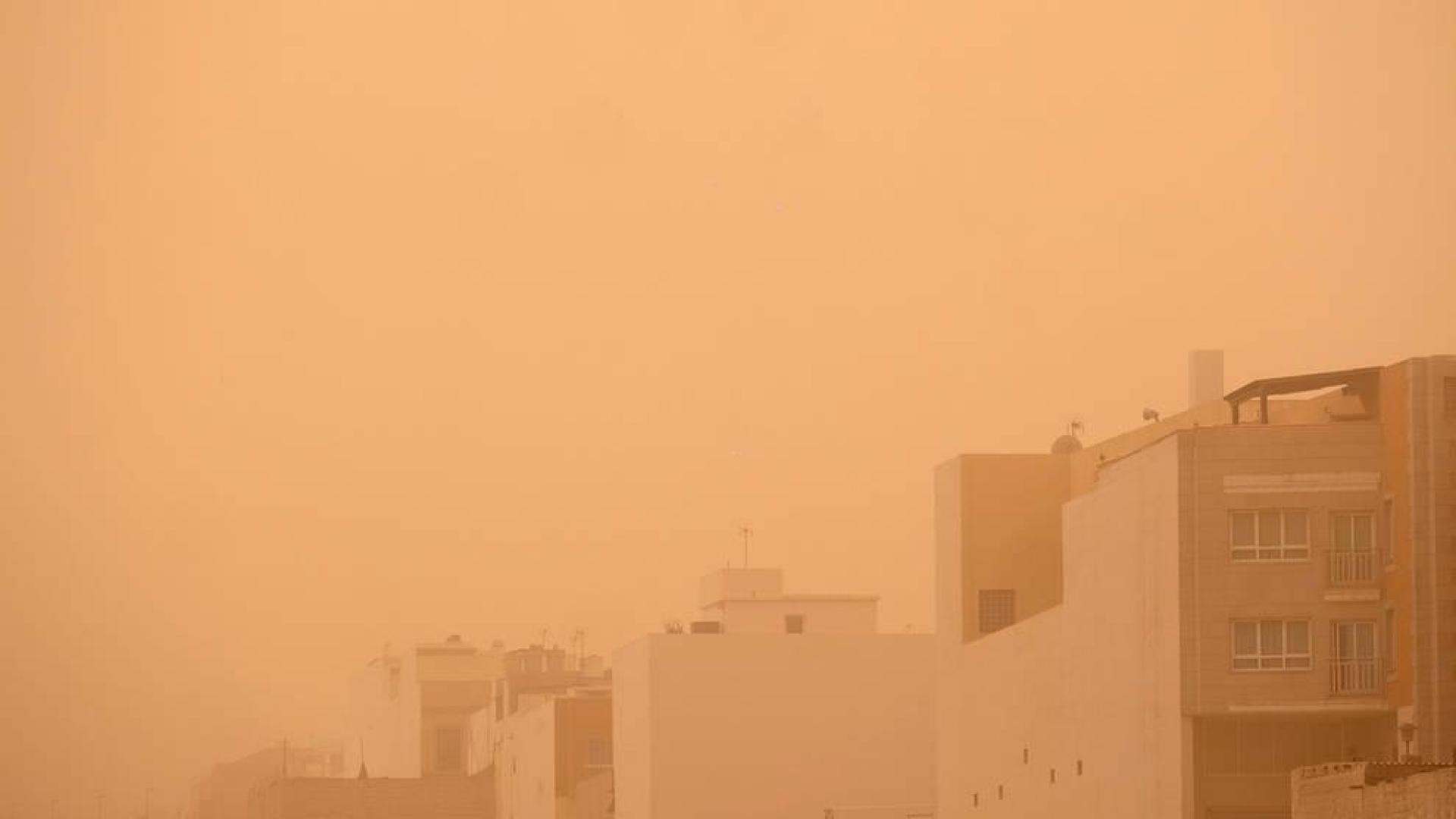 Un hombre pasea por el barrio de Majada Marical, cubierto por una densa calima procedente de África, este domingo en Puerto del Rosario (Fuerteventura).