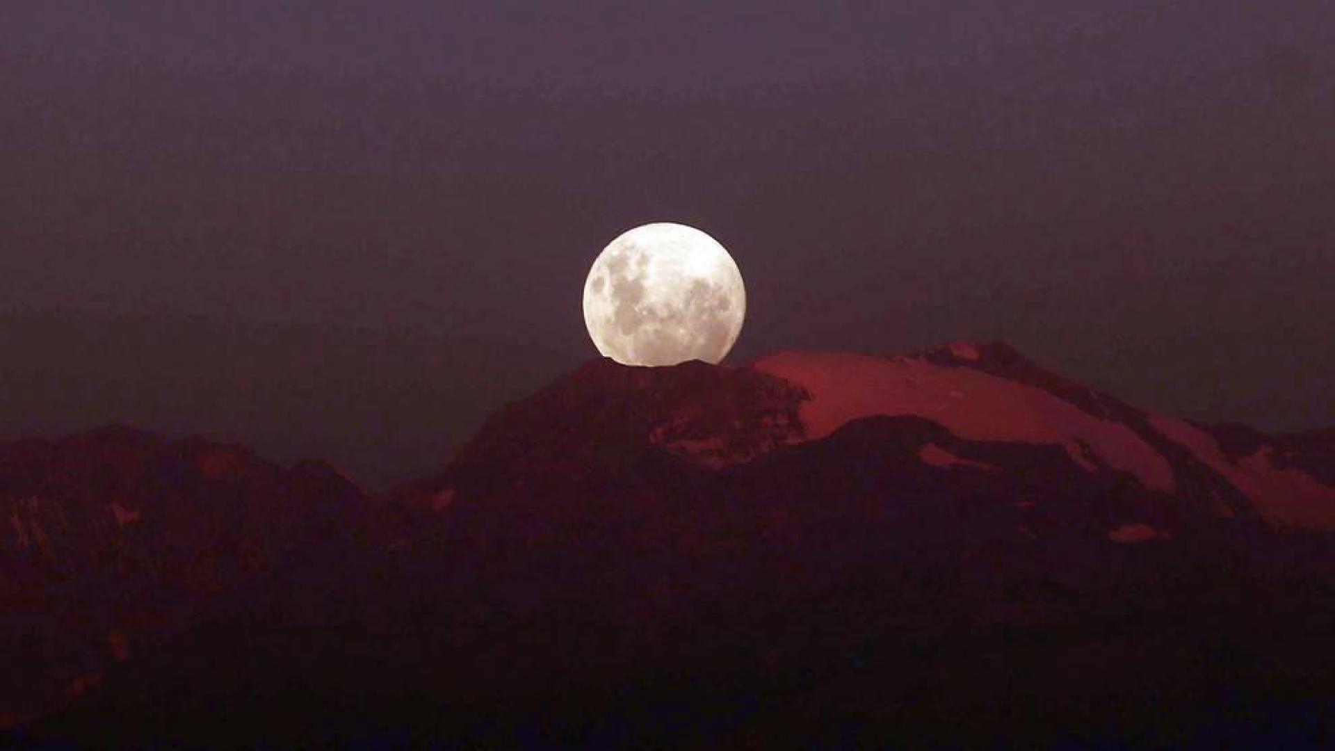 La luna se tiñe de color rojizo en un eclipse total seguido en medio mundo