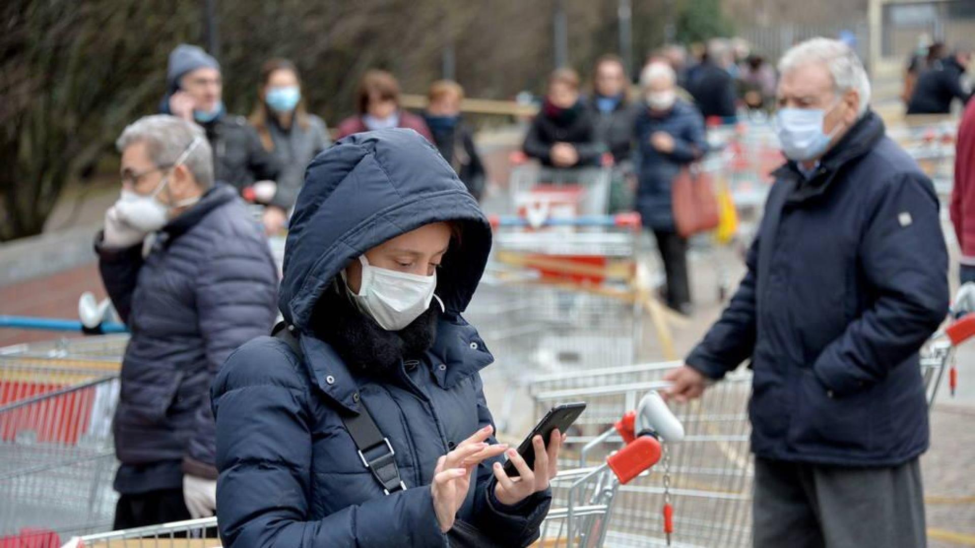 Personas con máscara hace cola en una supermercado en Italia.