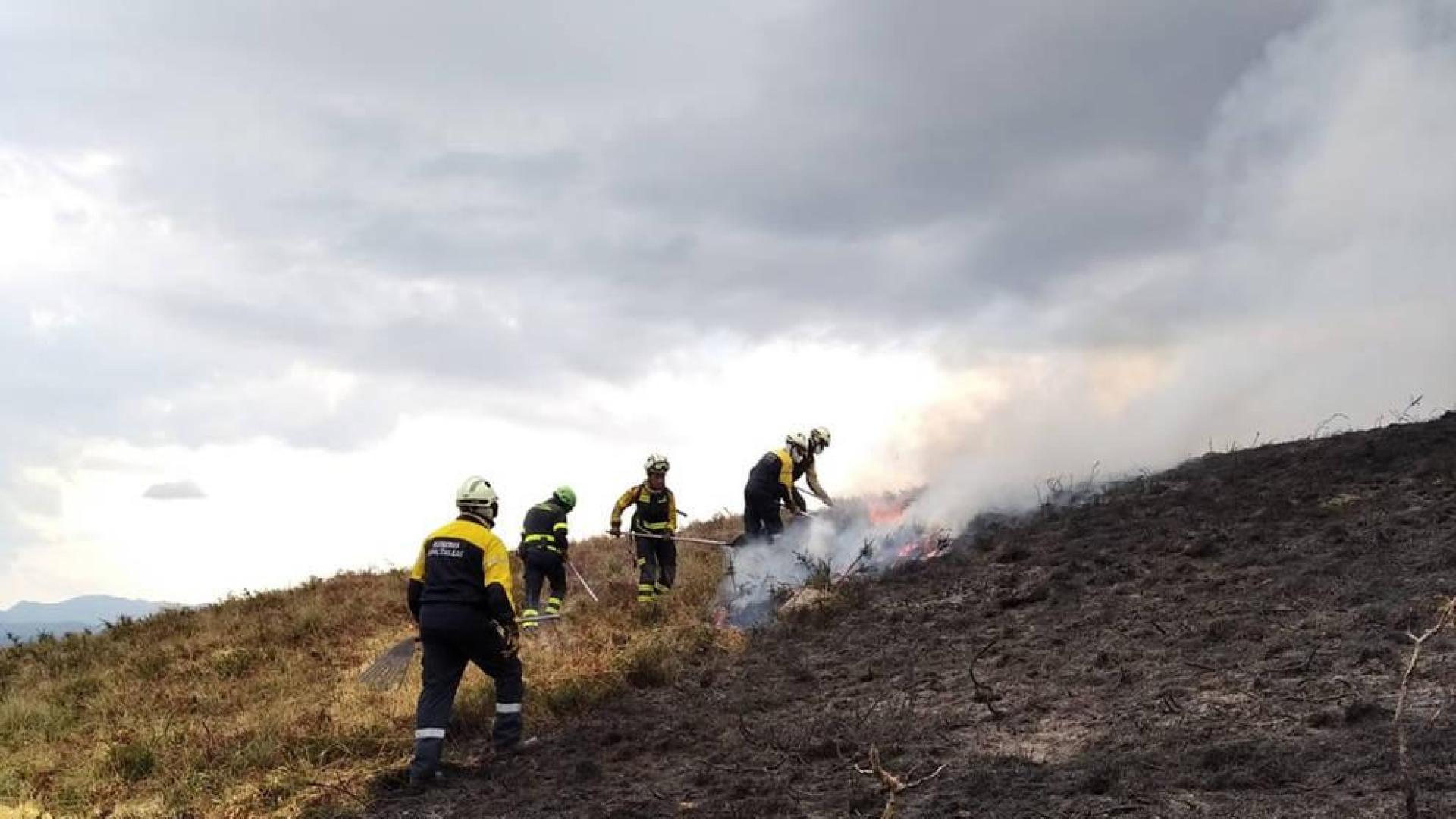 Bomberos trabajan en una quema de pastos de montaña.