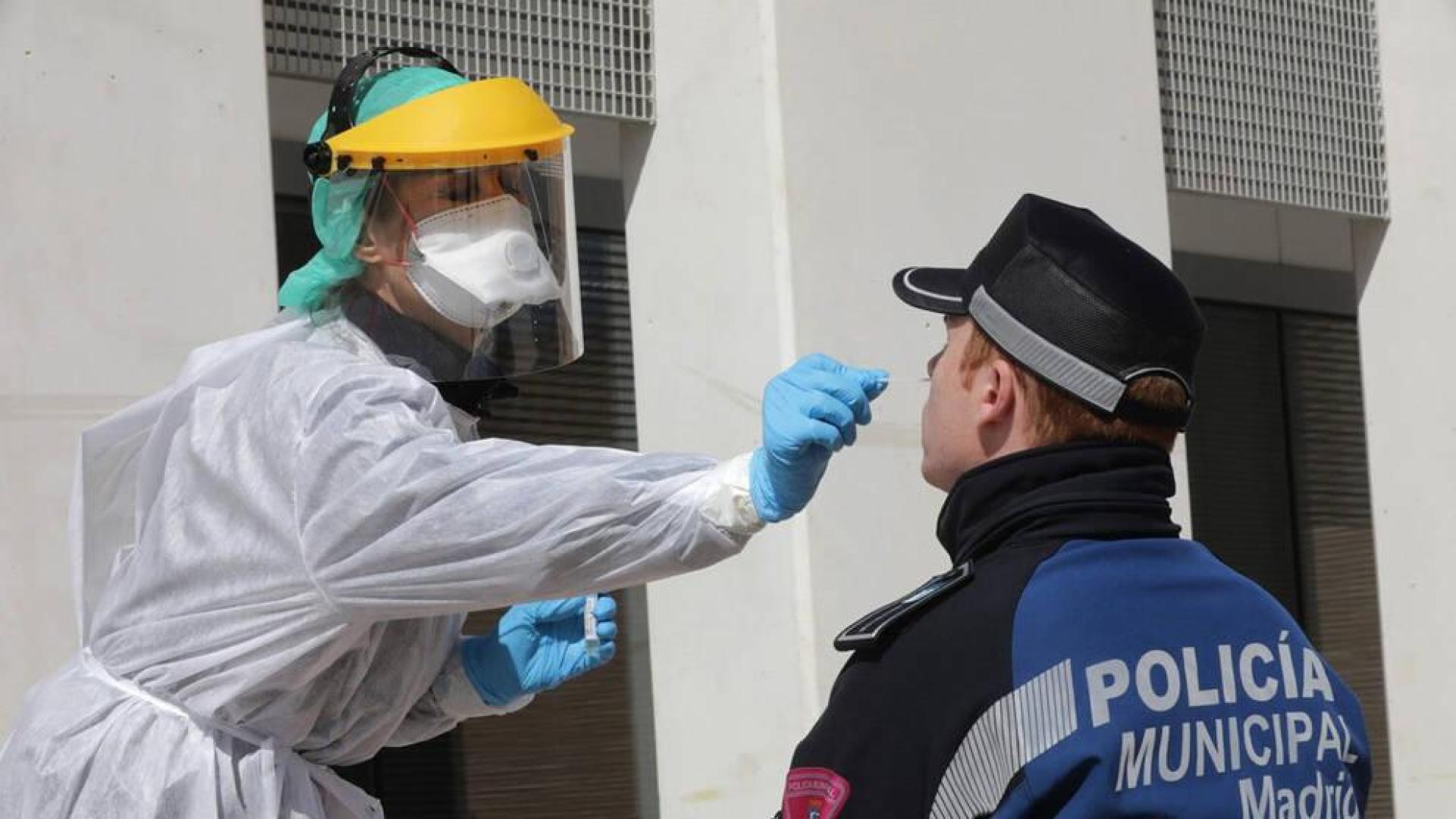 Una sanitaria realiza un test a un policía municipal de Madrid.