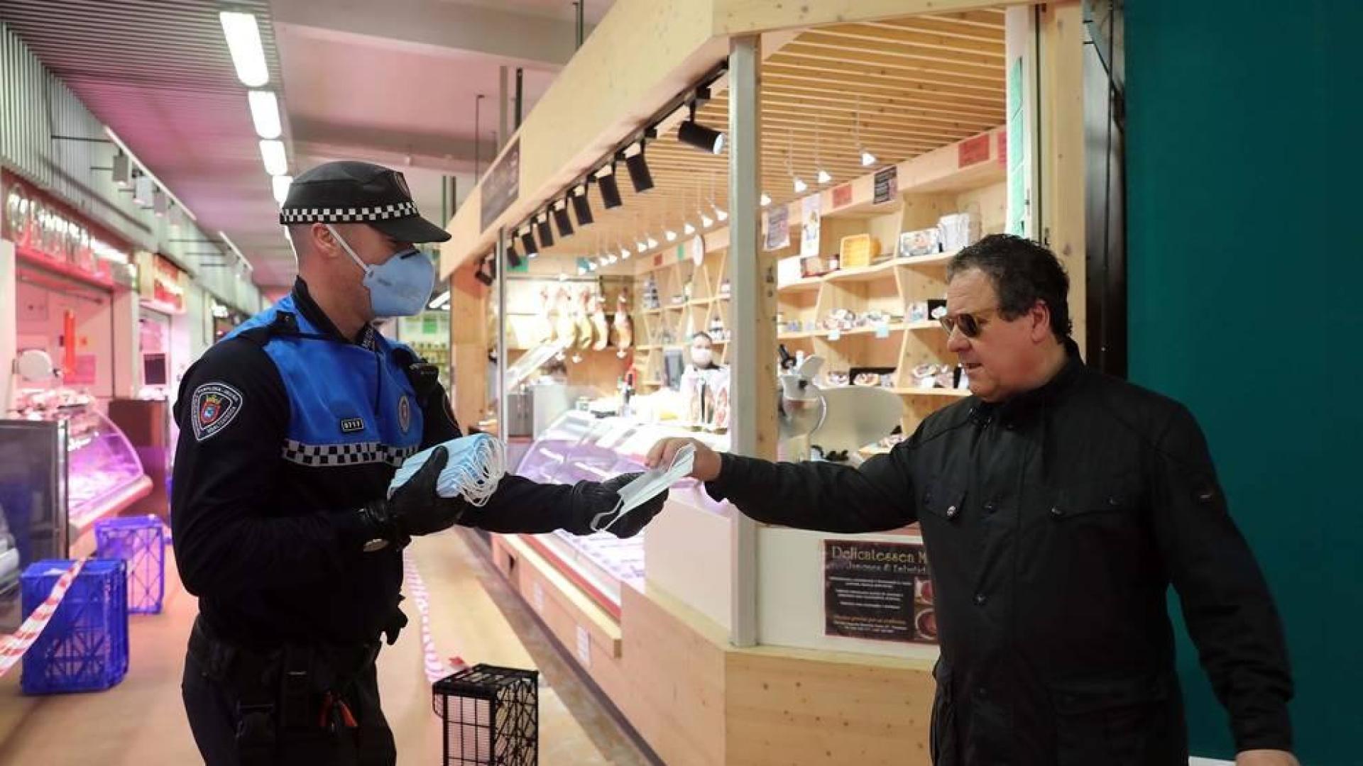 Agentes reparten mascarillas para prevenir el coronavirus en Pamplona.