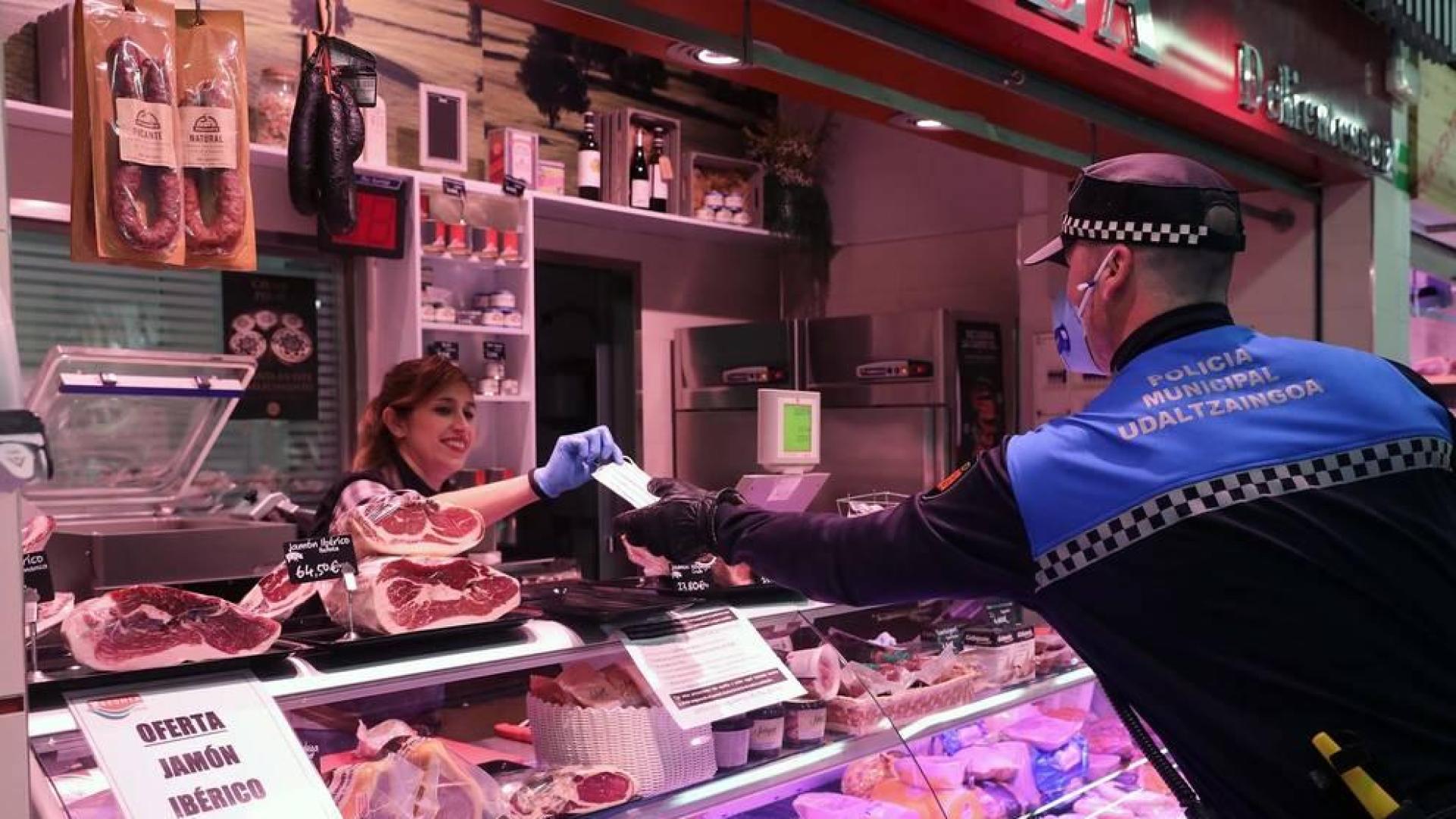 Agentes reparten mascarillas para prevenir el coronavirus en Pamplona.