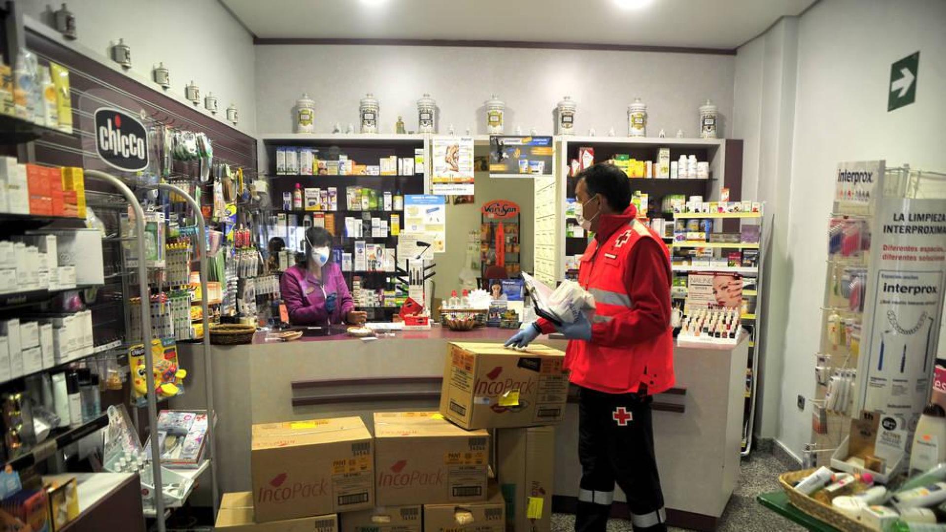 Pedro Arzoz recoge lo medicamentos que repartirá Cruz Roja en una farmacia de Tafalla.