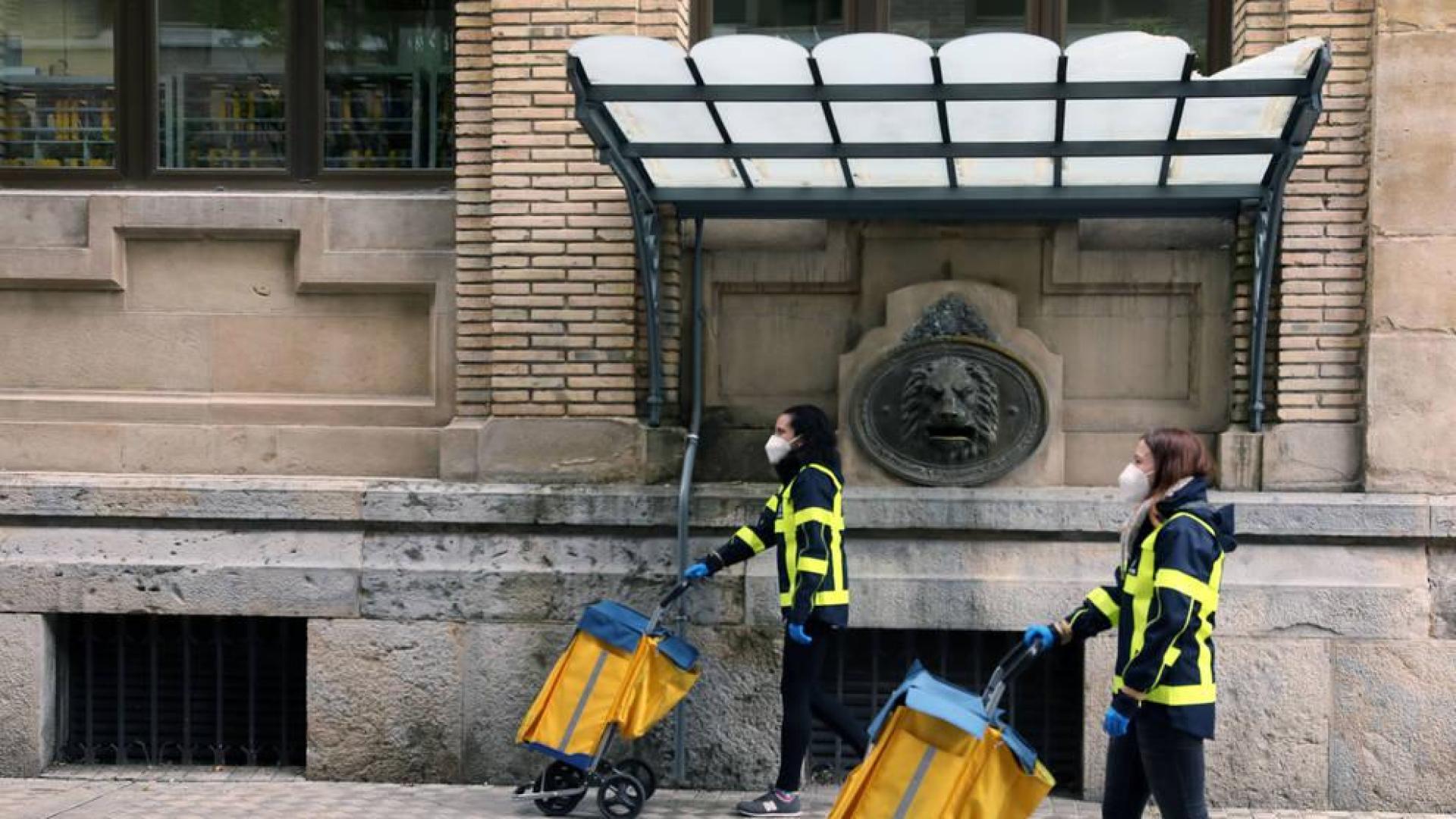 Dos carteras con los carritos de reparto en Pamplona