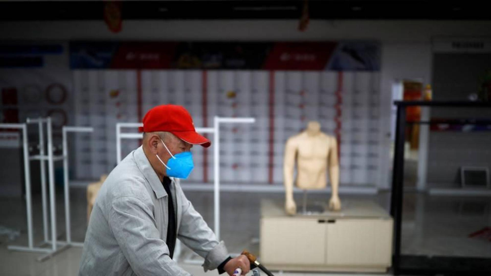 Un hombre empuja un carrito de la compra en Beijing.