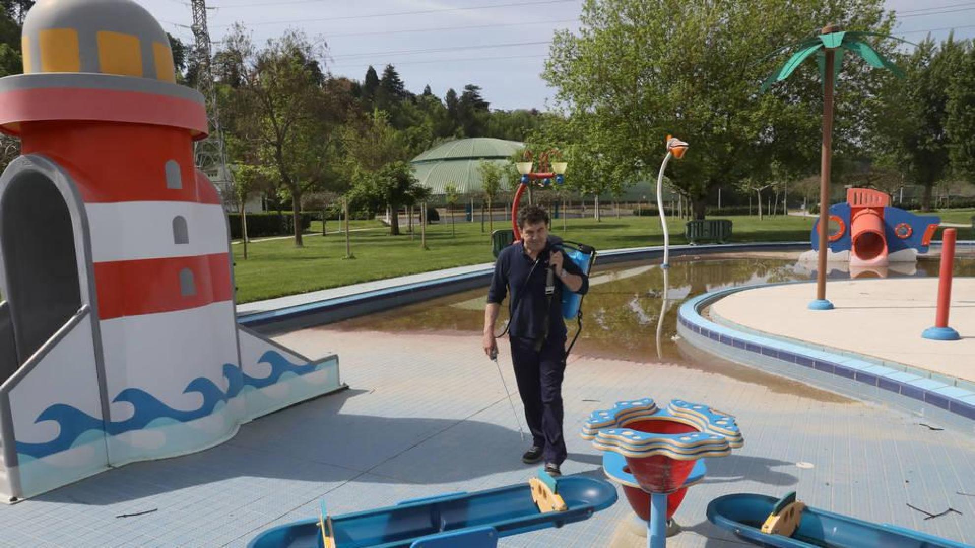 Un operario de mantenimiento del club deportivo Amaya, limpiando la zona de las piscinas infantiles.