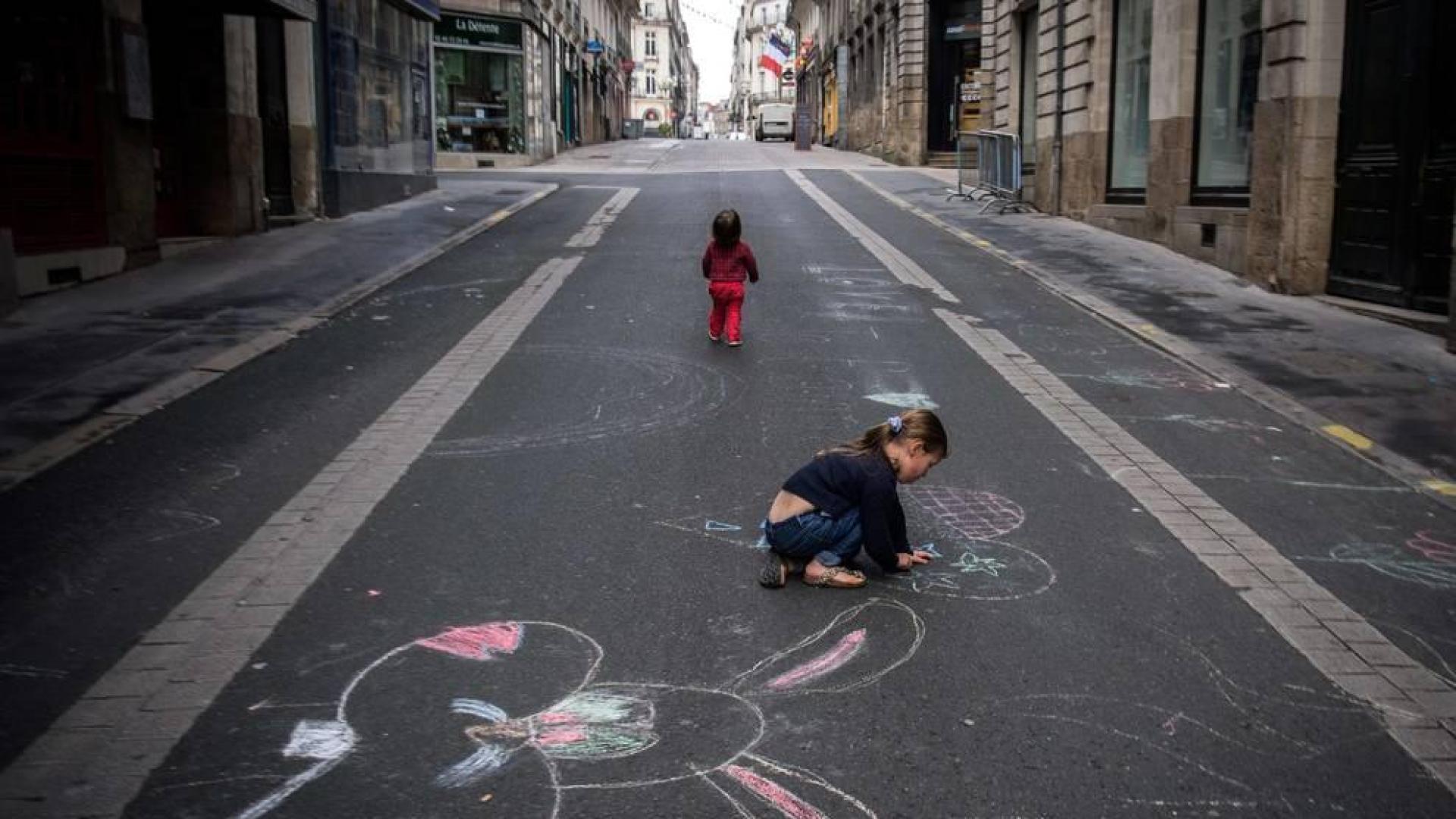 Una niña pinta una calle en Nantes.