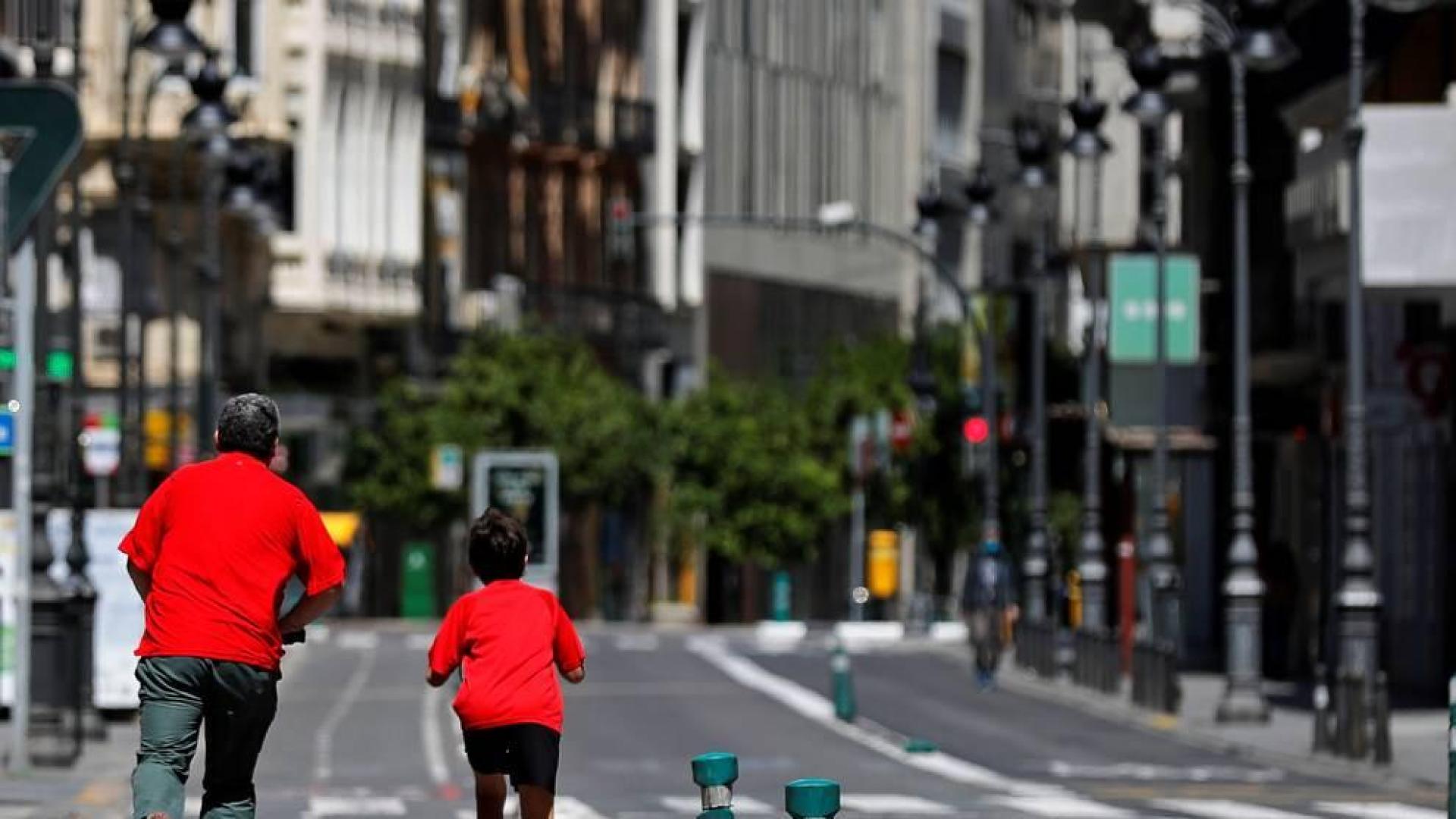 Un niño y un adulto, en una calle de Valencia.