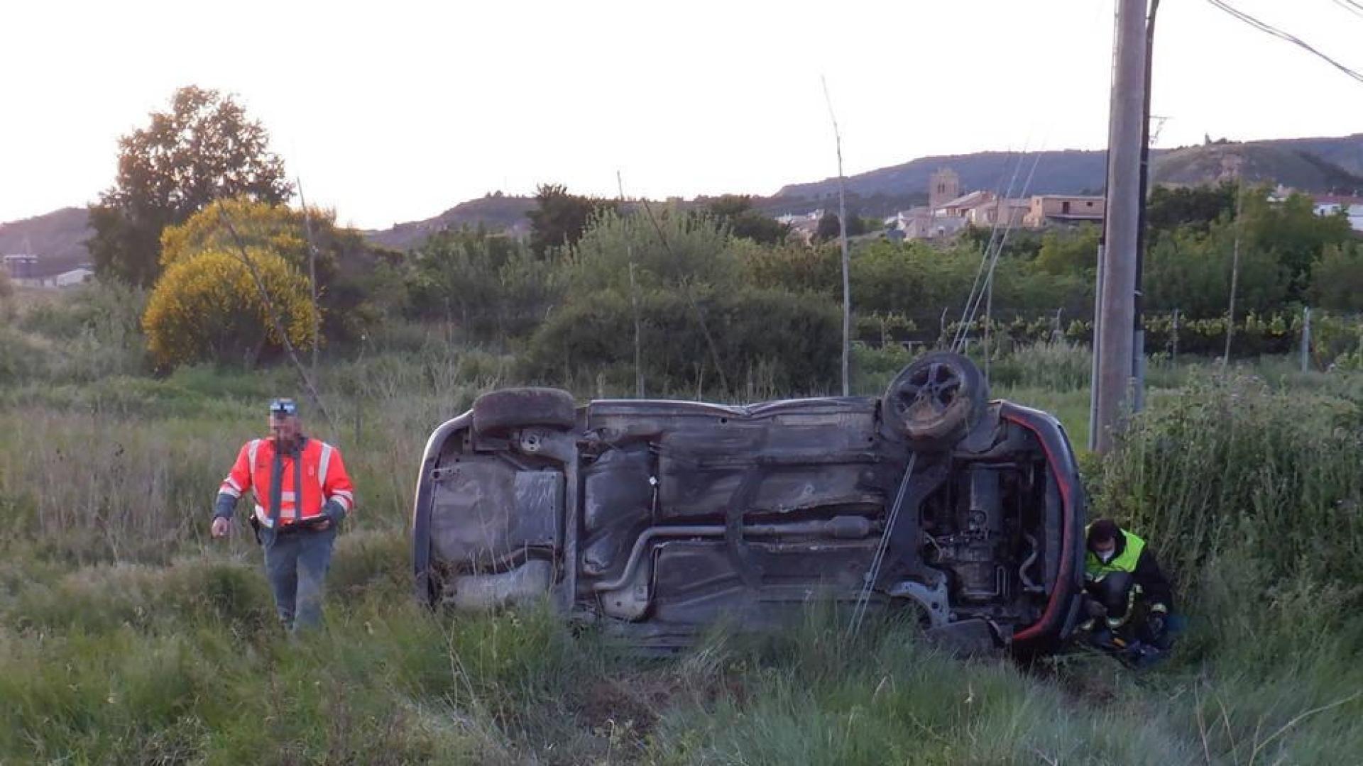 Un agente de la Policía Foral, junto al vehículo accidentado.