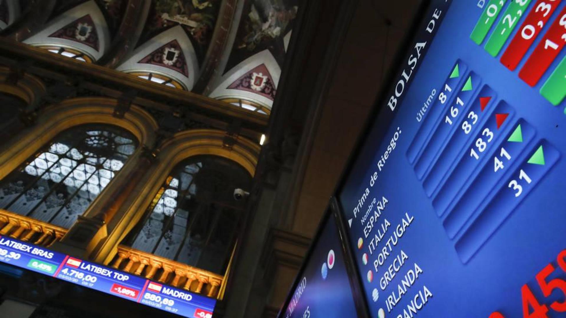 Vista de los paneles que informan sobre la prima de riesgo en el parqué de la Bolsa de Madrid este jueves.