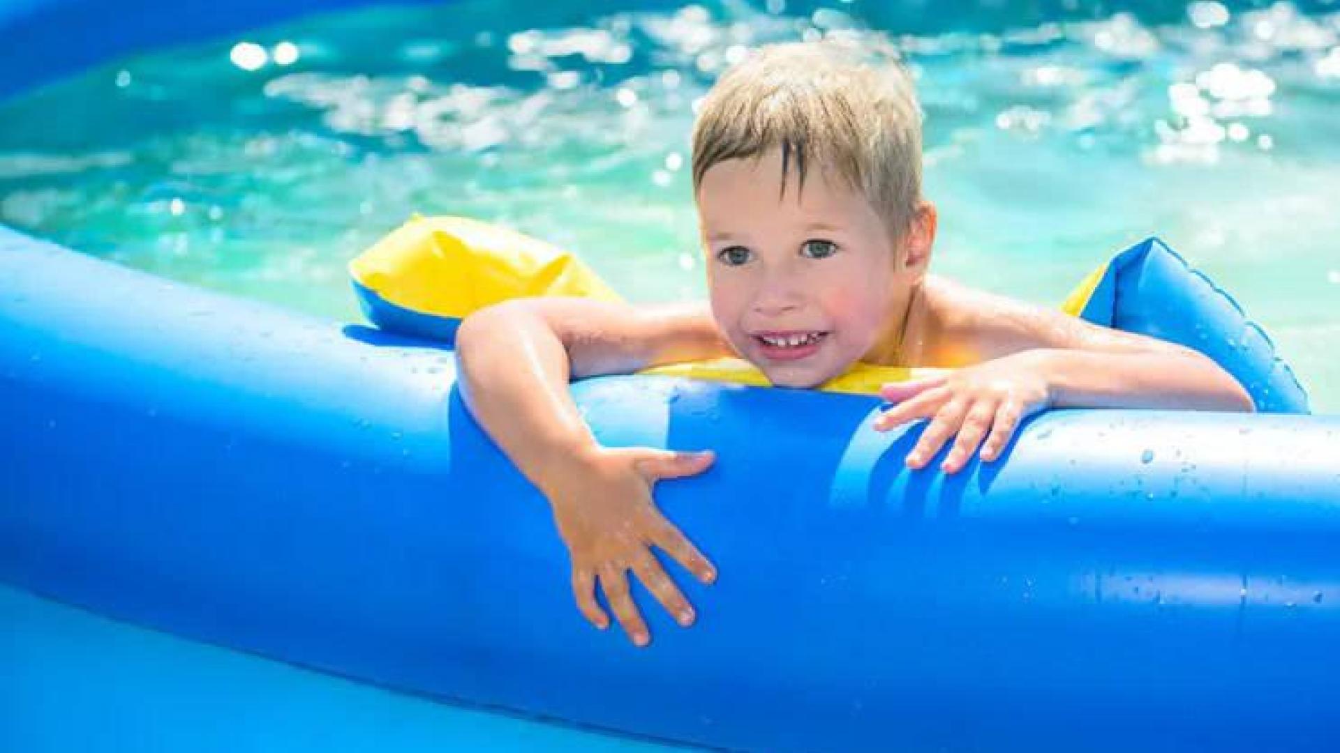 Un niño, en una piscina de plástico.