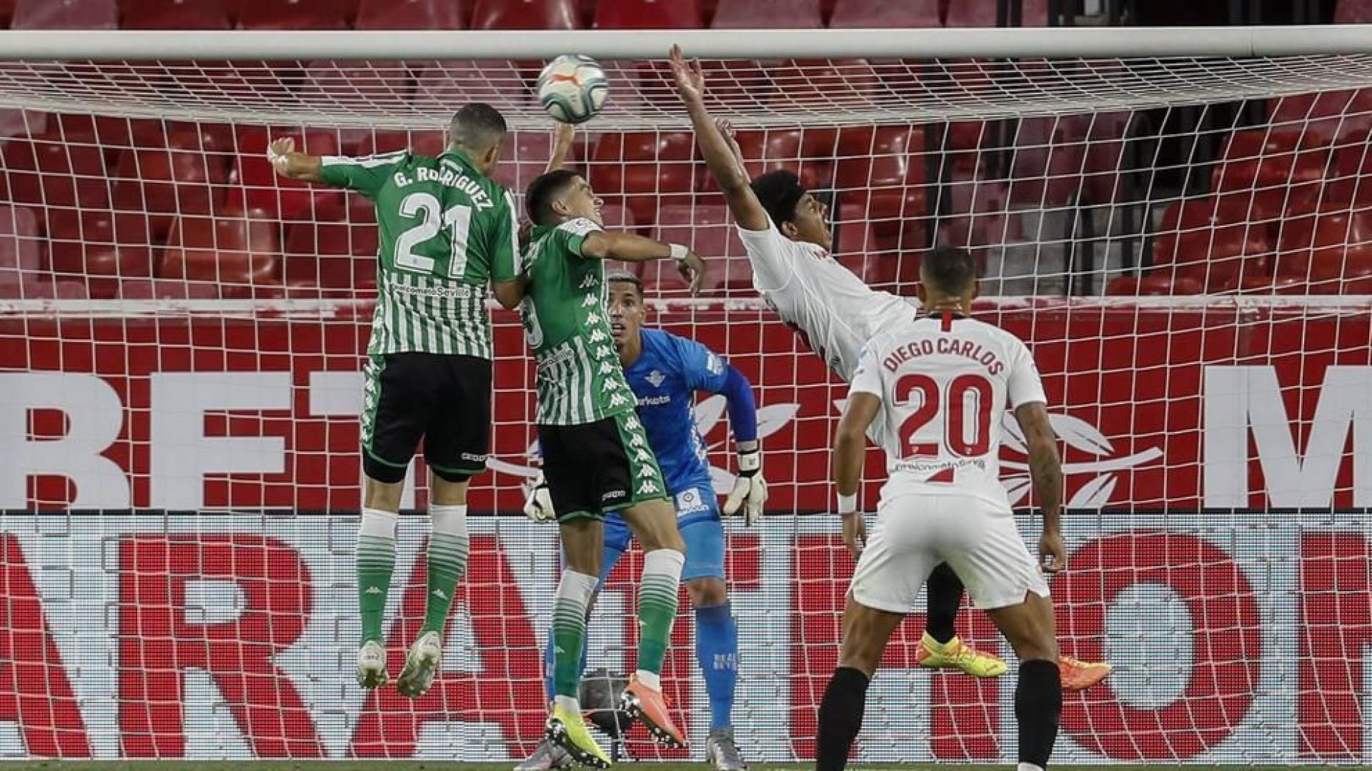El defensa francés del Sevilla, Jules Koundé (2d), intenta rematar un balón ante el defensa del Betis, Marc Bartra (2i), durante el encuentro correspondiente a la jornada 28 de primera división