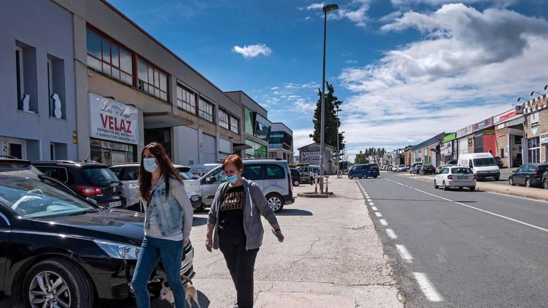 Dos personas caminan por el polígono de Merkatondoa de Estella con mascarilla.