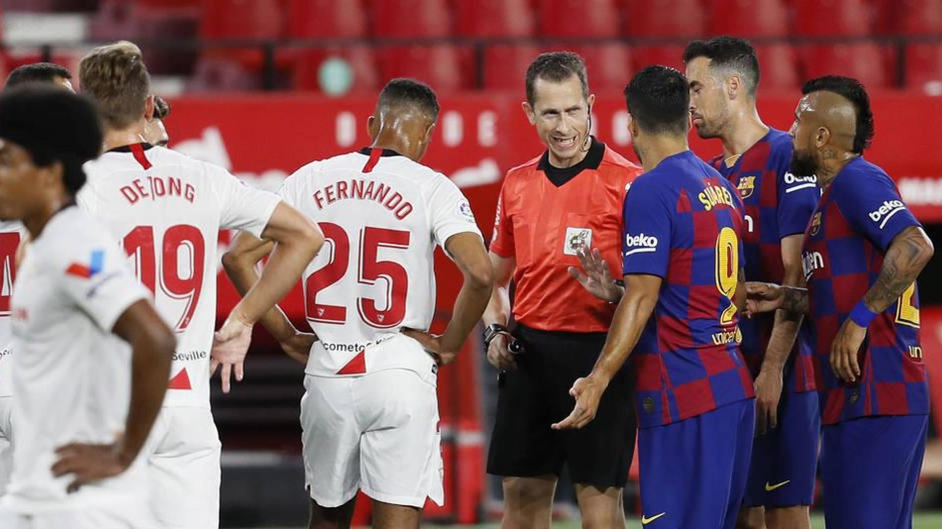 El arbitro del encuentro, González González (C) conversa con el delantero uruguayo del FC Barcelona, Luis Suárez (3d)