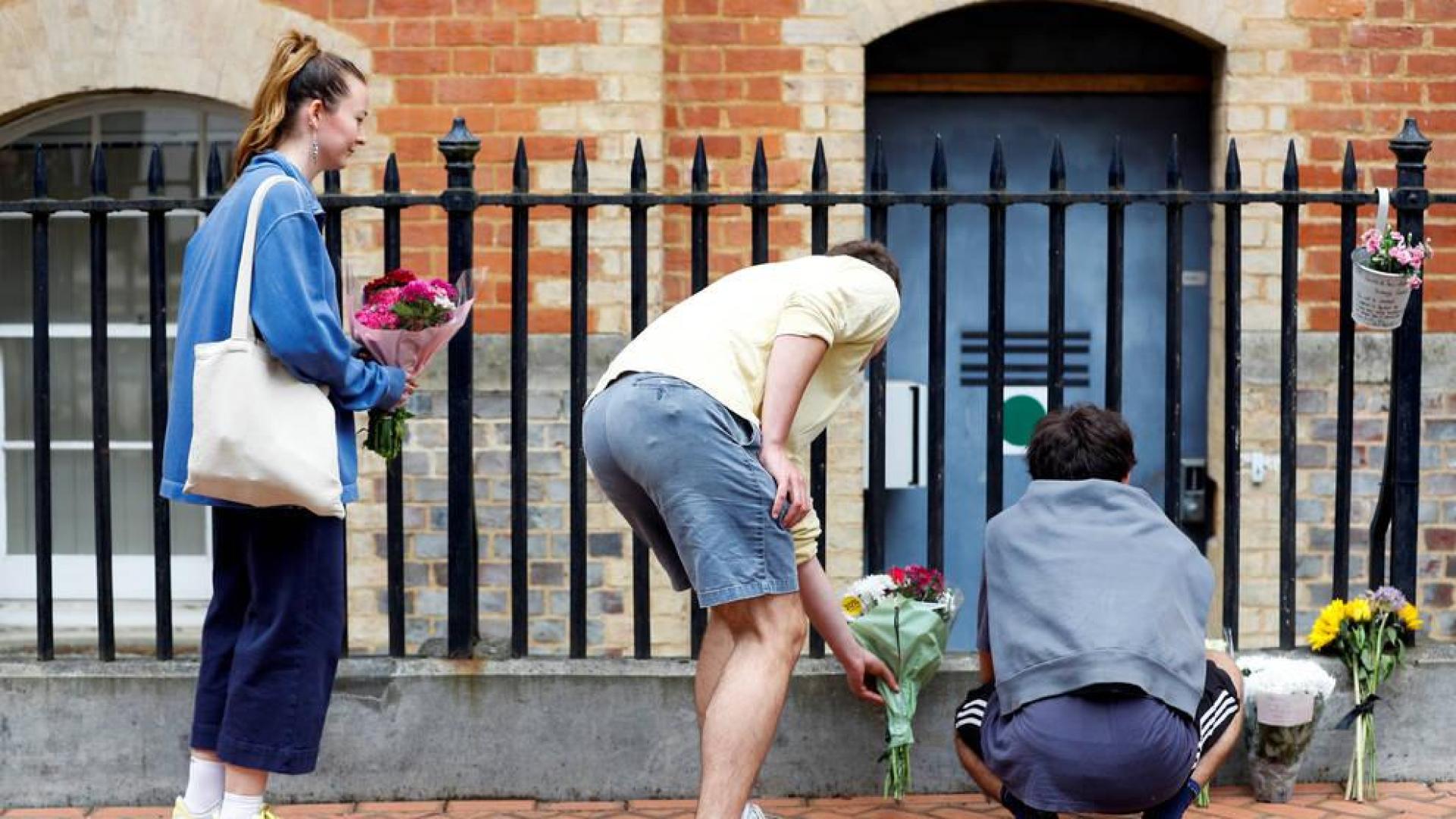 Varias personas dejan flores en el lugar de los apuñalamientos en Reading.