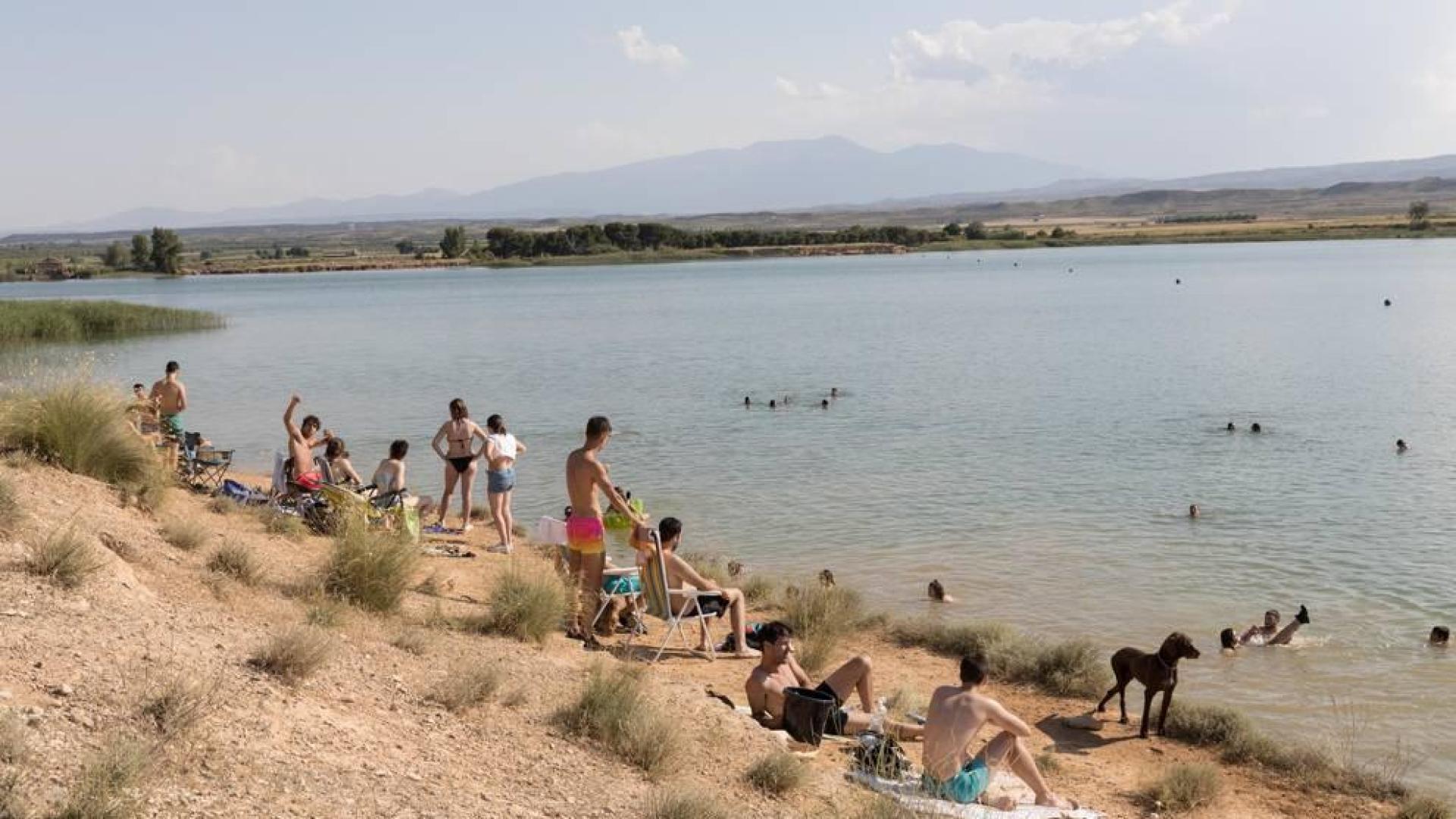 Muchas cuadrillas y familias disfrutan de bañarse y tomar el sol en hamacas y toallas a la orilla de la balsa El Pulguer, única zona de baño natural en la Ribera.
