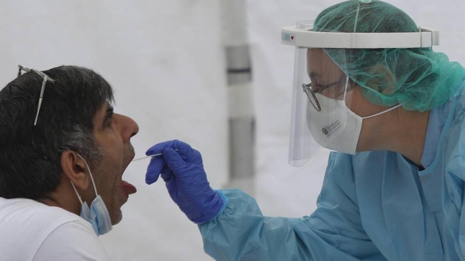 Una sanitaria le realiza un frotis bucal a un vecino de Ordizia en una de las carpas instaladas en el parque Barrena por el Ayuntamiento de Ordizia para realizar test ante el posible brote de COVID-19 detectado en la localidad guipuzcoana.