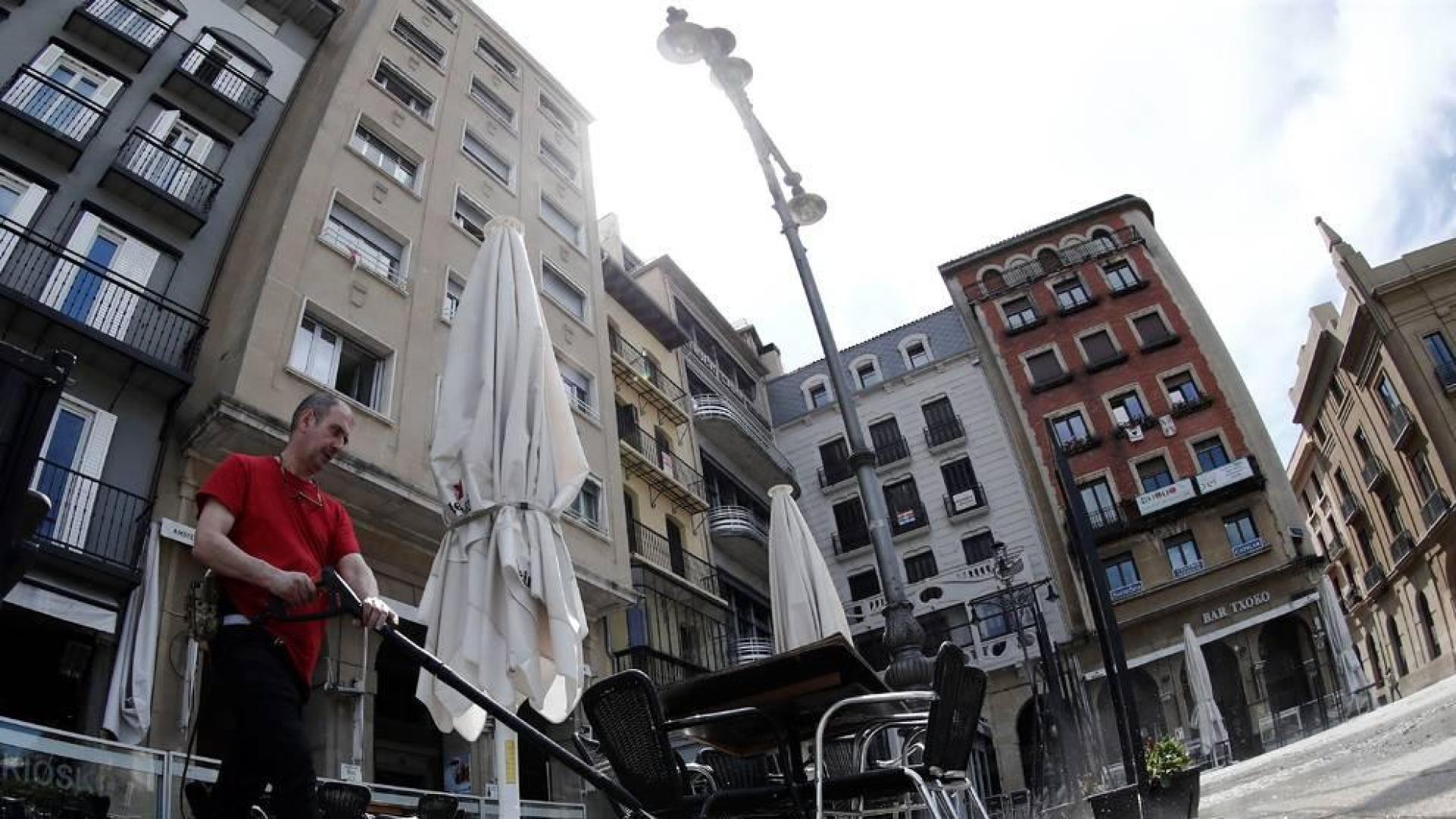 El dueño de un bar de la Plaza del Castillo desinfecta su terraza.