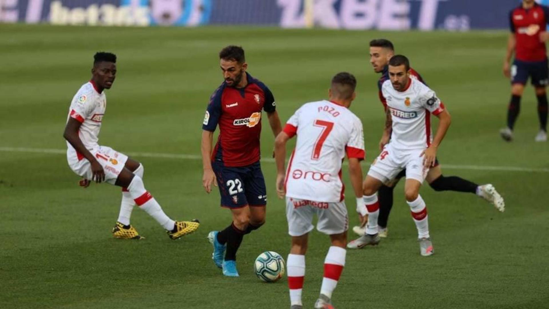 Adrián, rodeado de jugadores del Mallorca, este domingo en El Sadar.