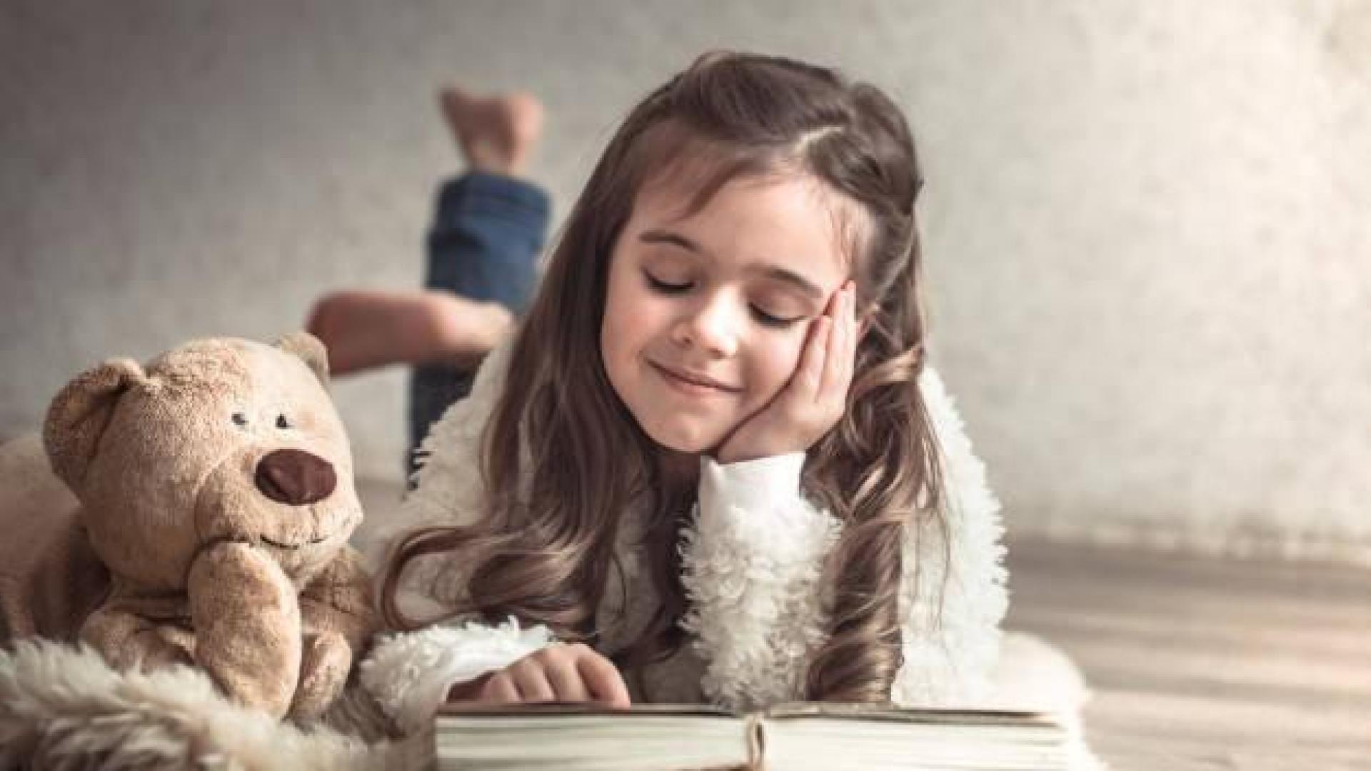 Imagen de una niña leyendo sobre la cama
