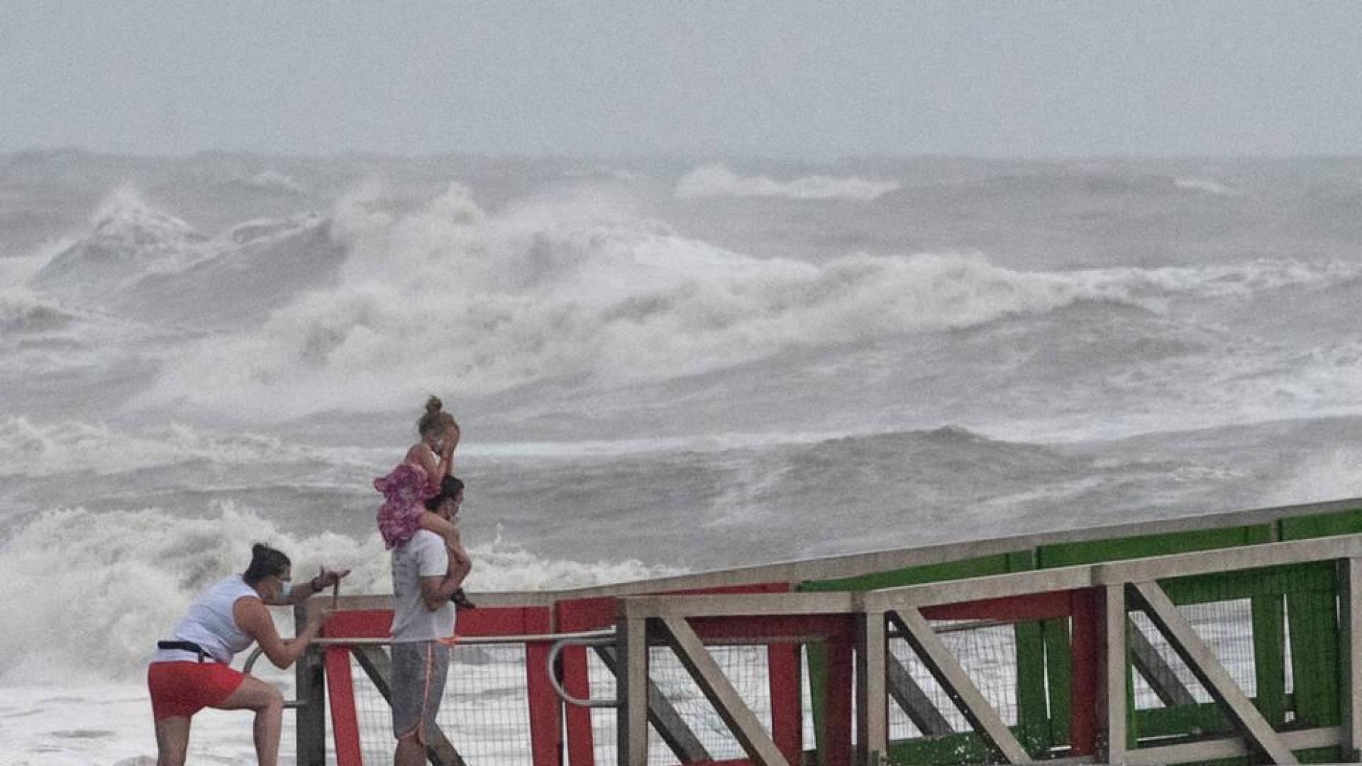 Una familia observa el mar en la llegada del huracán 'Hanna' a Texas
