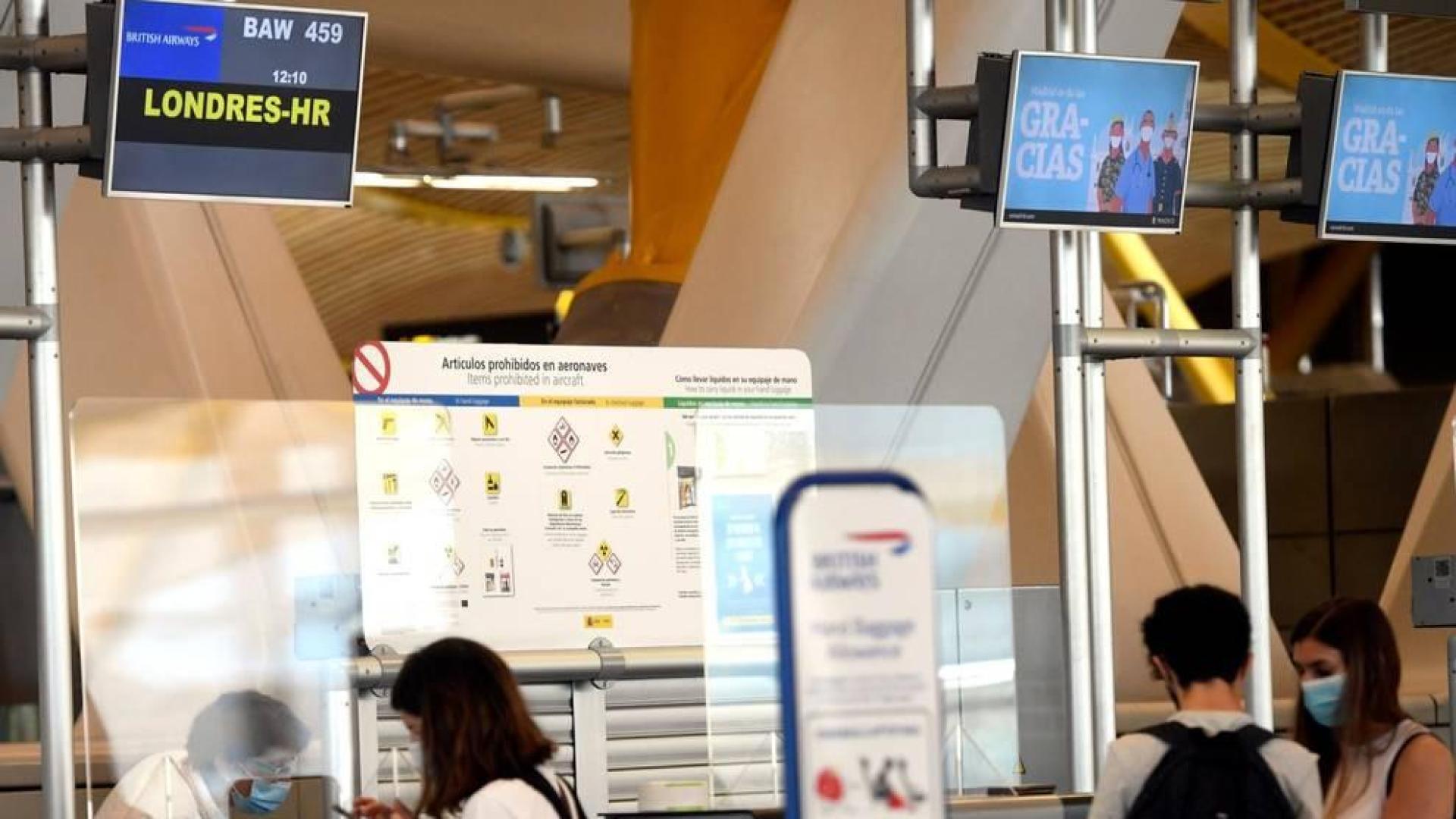 Jóvenes en la ventanilla de facturación para un vuelo con destino Londres, en la terminal T4 del Aeropuerto de Madrid-Barajas