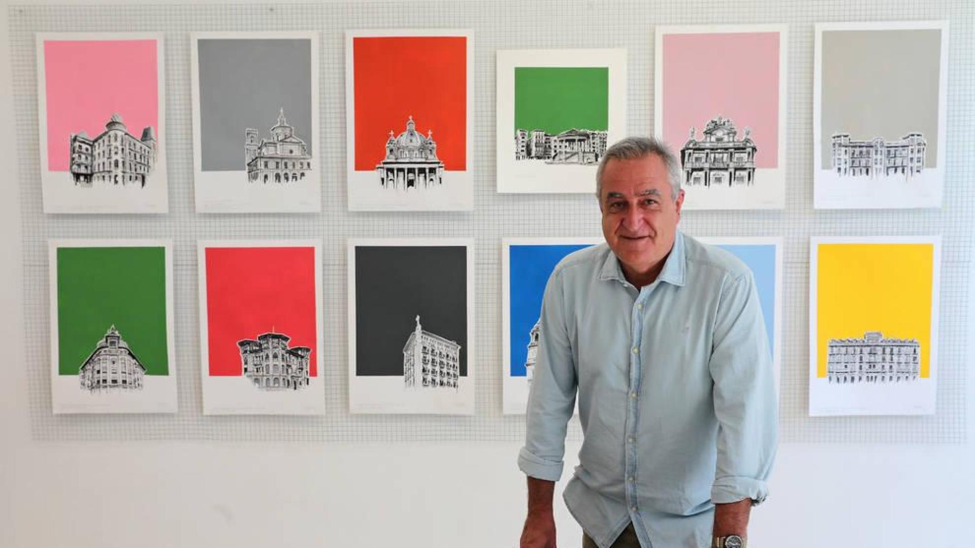 Iñaki Pardos posa junto a algunas de sus obras de fondos coloristas sobre edificios emblemáticos y reconocibles de Pamplona.