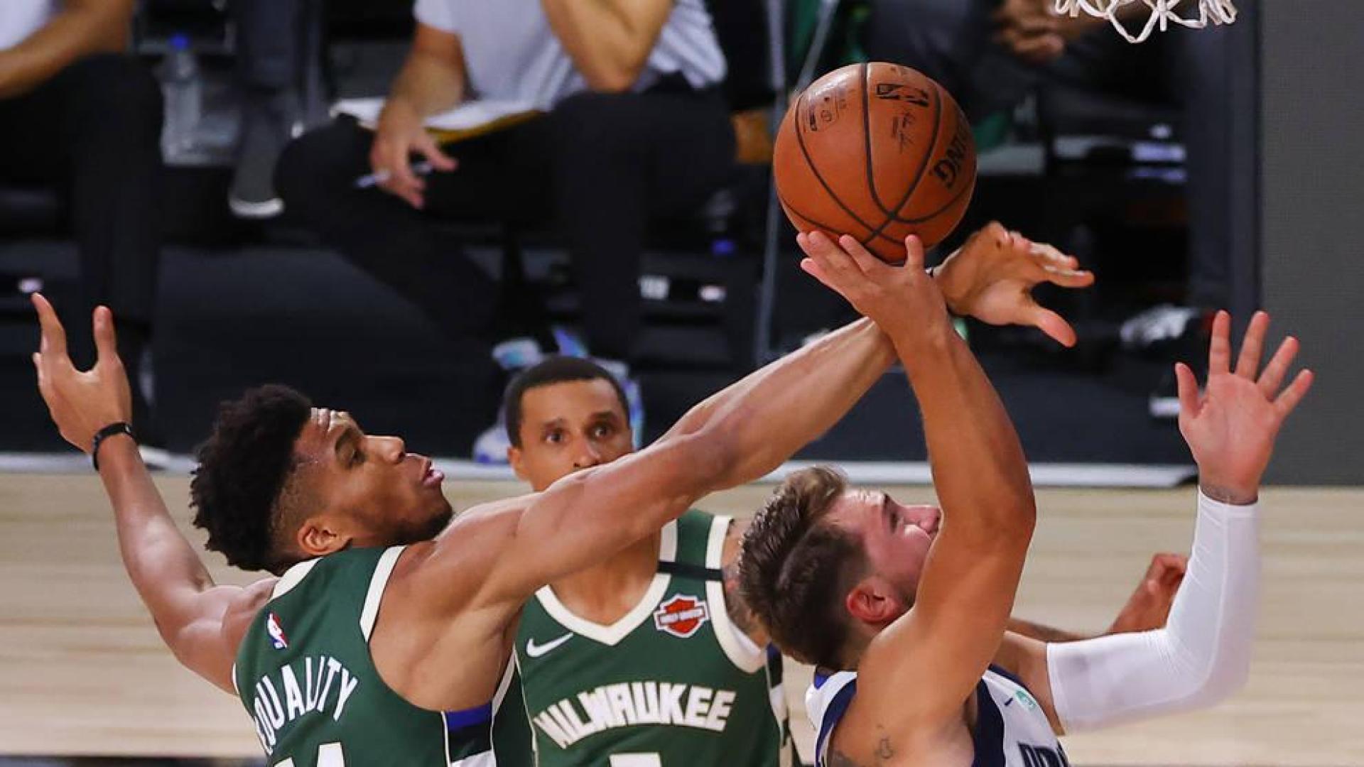 Antetokounmpo trata de bloquear a Doncic.