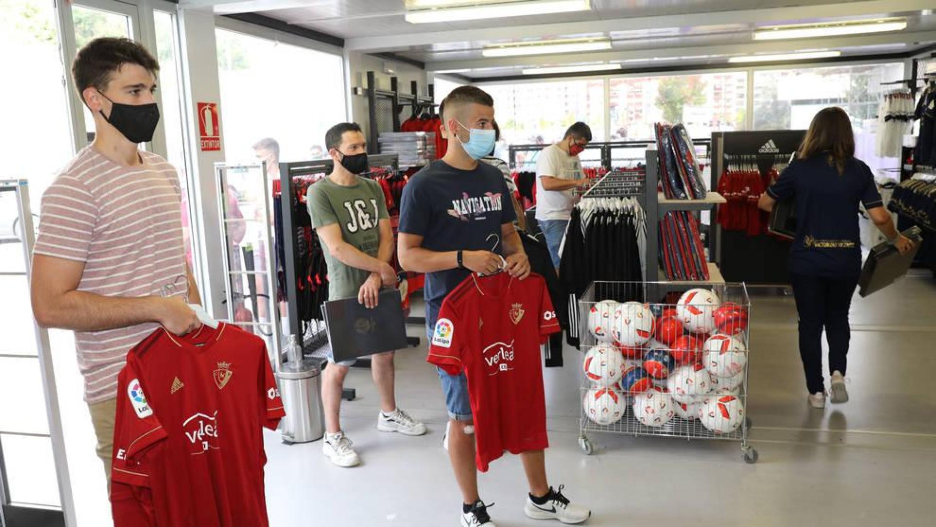 Aficionados de Osasuna en la tienda oficial adquiriendo las nuevas camisetas.
