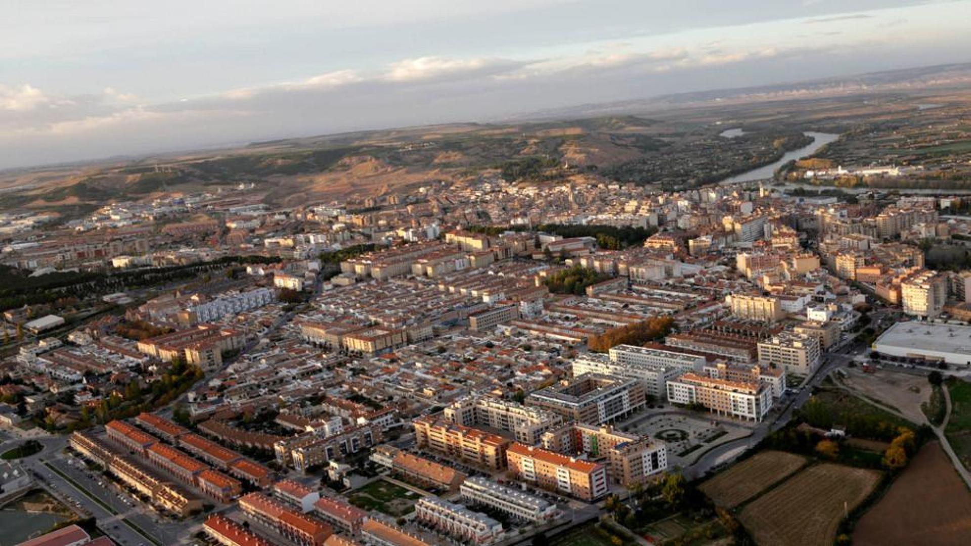 Vista aérea del casco urbano de Tudela con la urbanización del instituto y el barrio de Lourdes en primer término y, al fondo, el río Ebro.