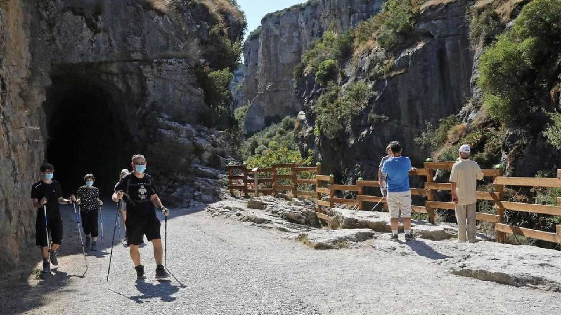 Diversos grupos de senderistas recorren, con la mascarilla puesta, la foz de Lumbier, uno de los atractivos naturales de la villa.