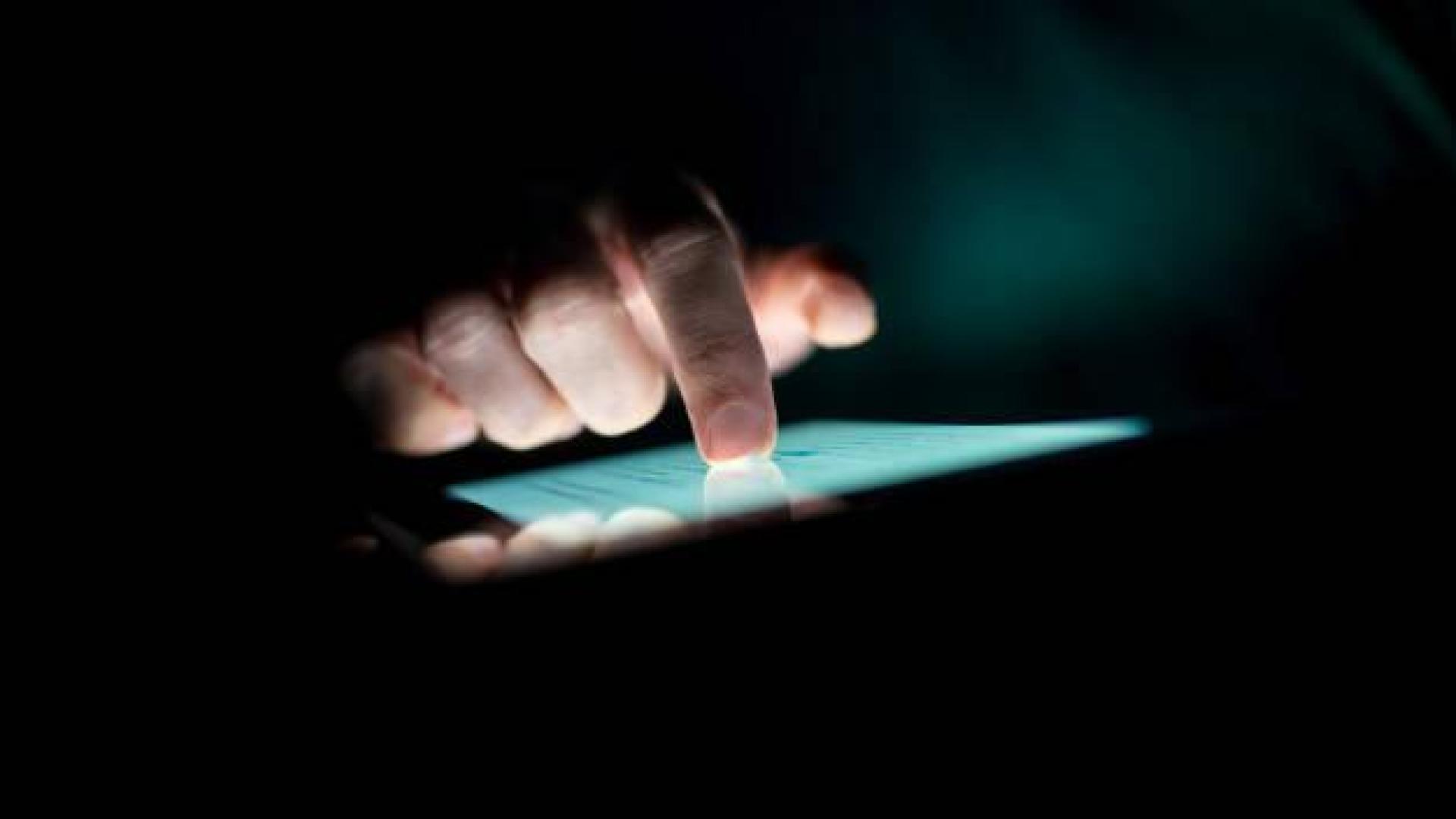 Imagen de una persona pulsando la pantalla táctil de un lector de ebooks