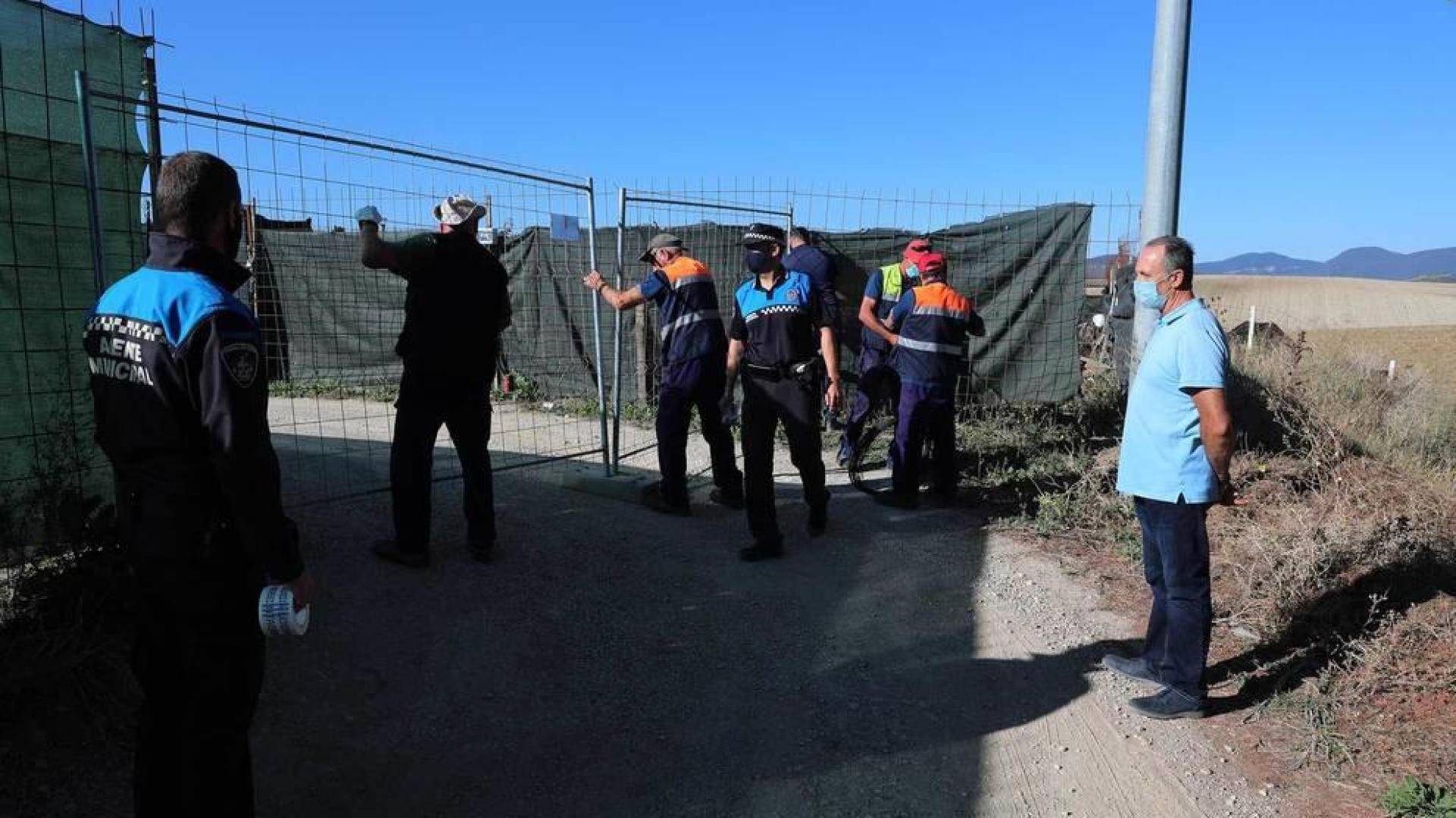 A la derecha, Tomás Labiano, propietario del terreno, observa cómo agentes y empleados municipales proceden al precinto de la instalación en Paternáin.