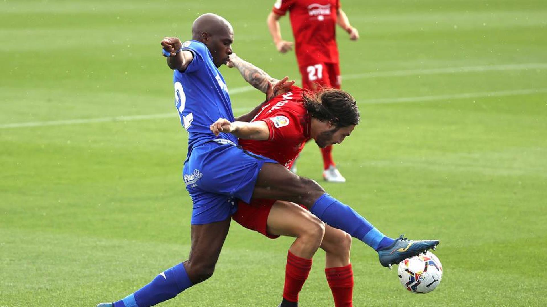 Nyom, en un lance del Getafe-Osasuna, pelea con Juan Cruz.