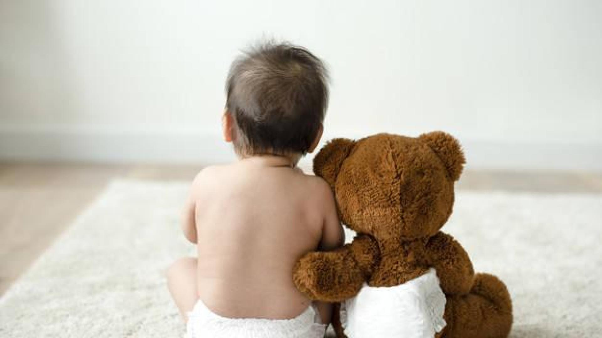 Imagen de un bebé con un osito de peluche