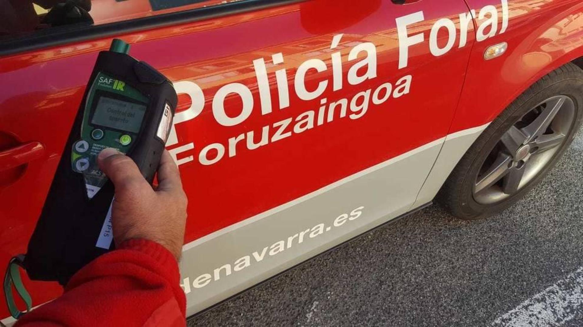 Un agente con un etilómetro indiciario en un control de alcoholemia.