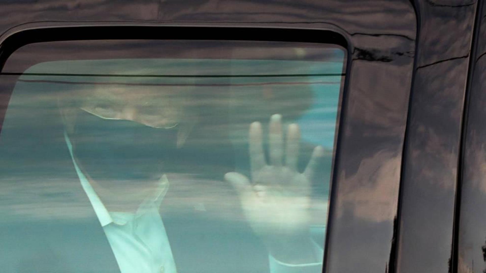 Trump saluda a sus simpatizantes desde el coche.