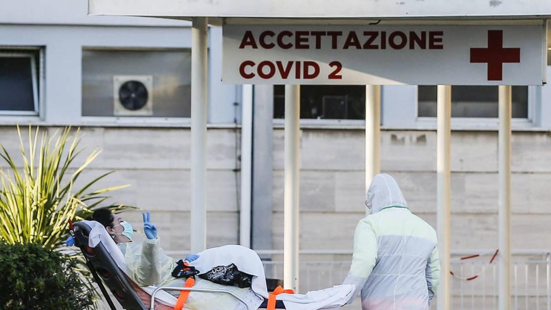 Una paciente hace la señal de la victoria a la entrada del hospital Gemelli, en Roma.