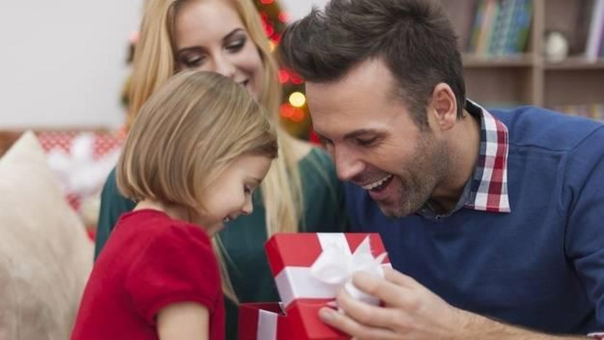 Imagen de un hombre abriendo un regalo de su familia
