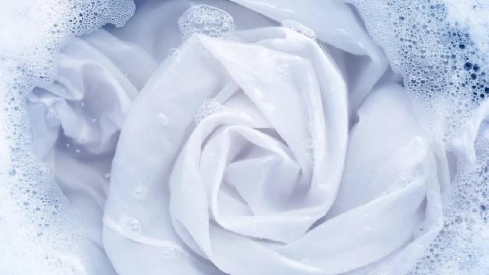 Imagen de ropa blanca sumergida en agua con detergente