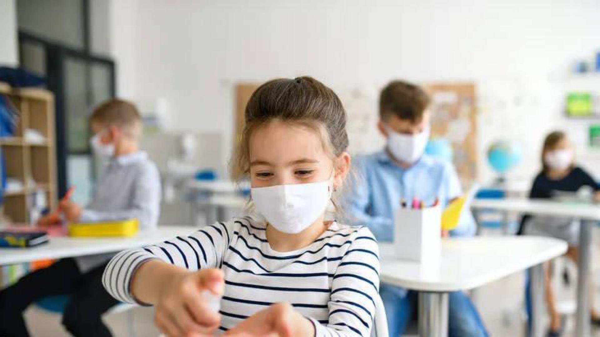 Una niña usa el gel hidroalcohólico.