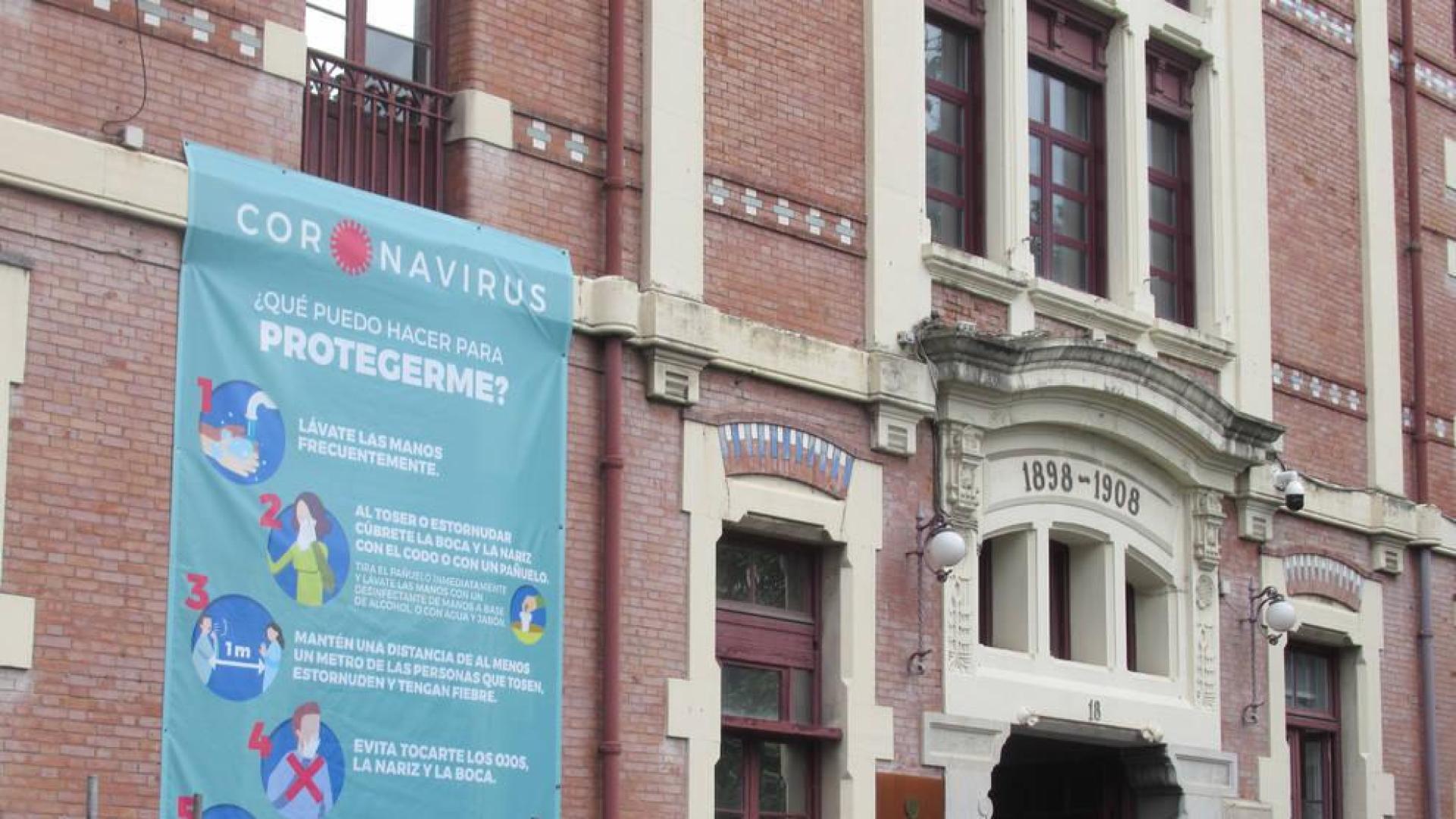 Cartel informativo sobre el coronavirus en la fachada del hospital de Basurto, en Bilbao