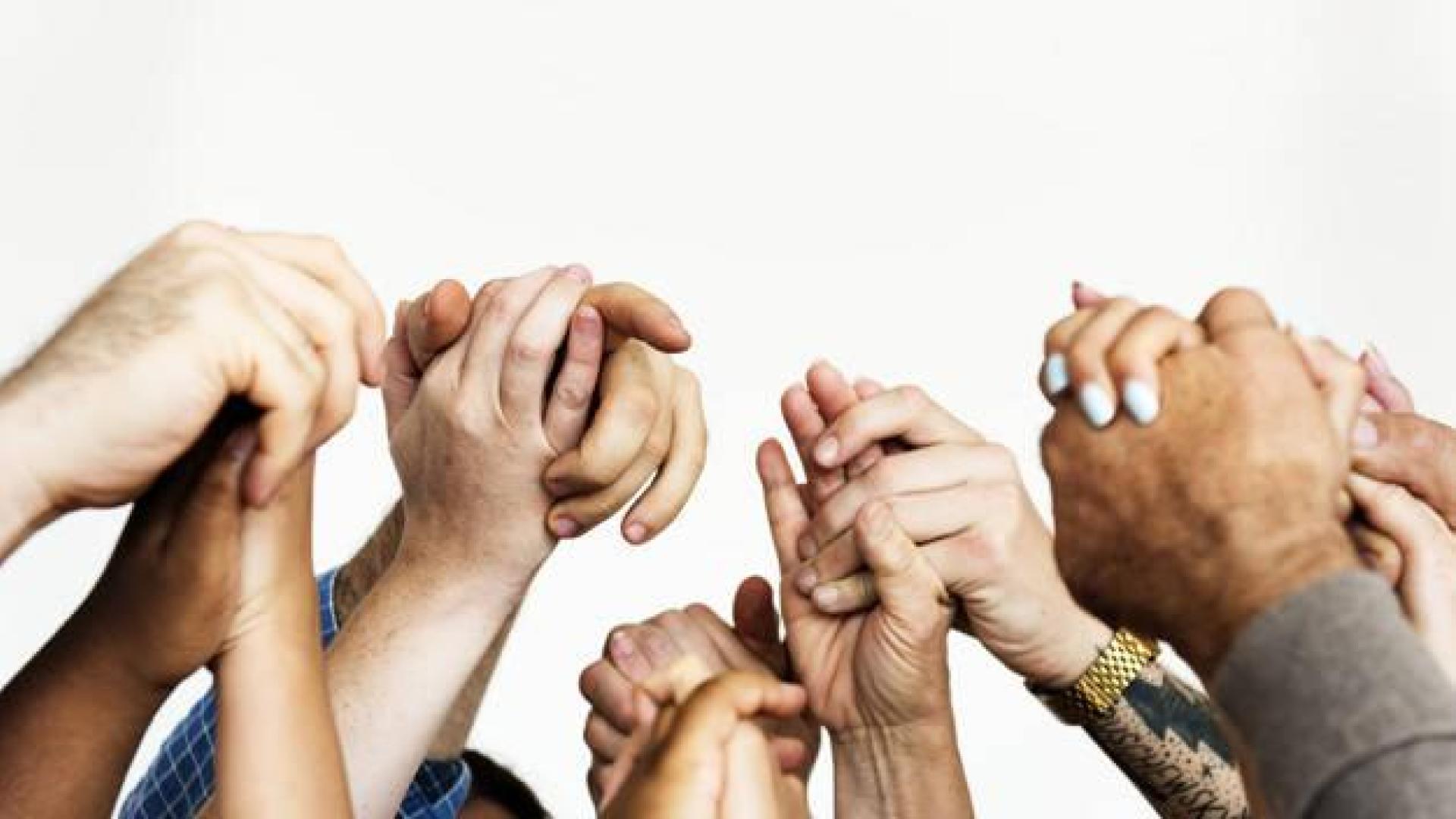 Imagen de diversas manos en alto entrelazadas
