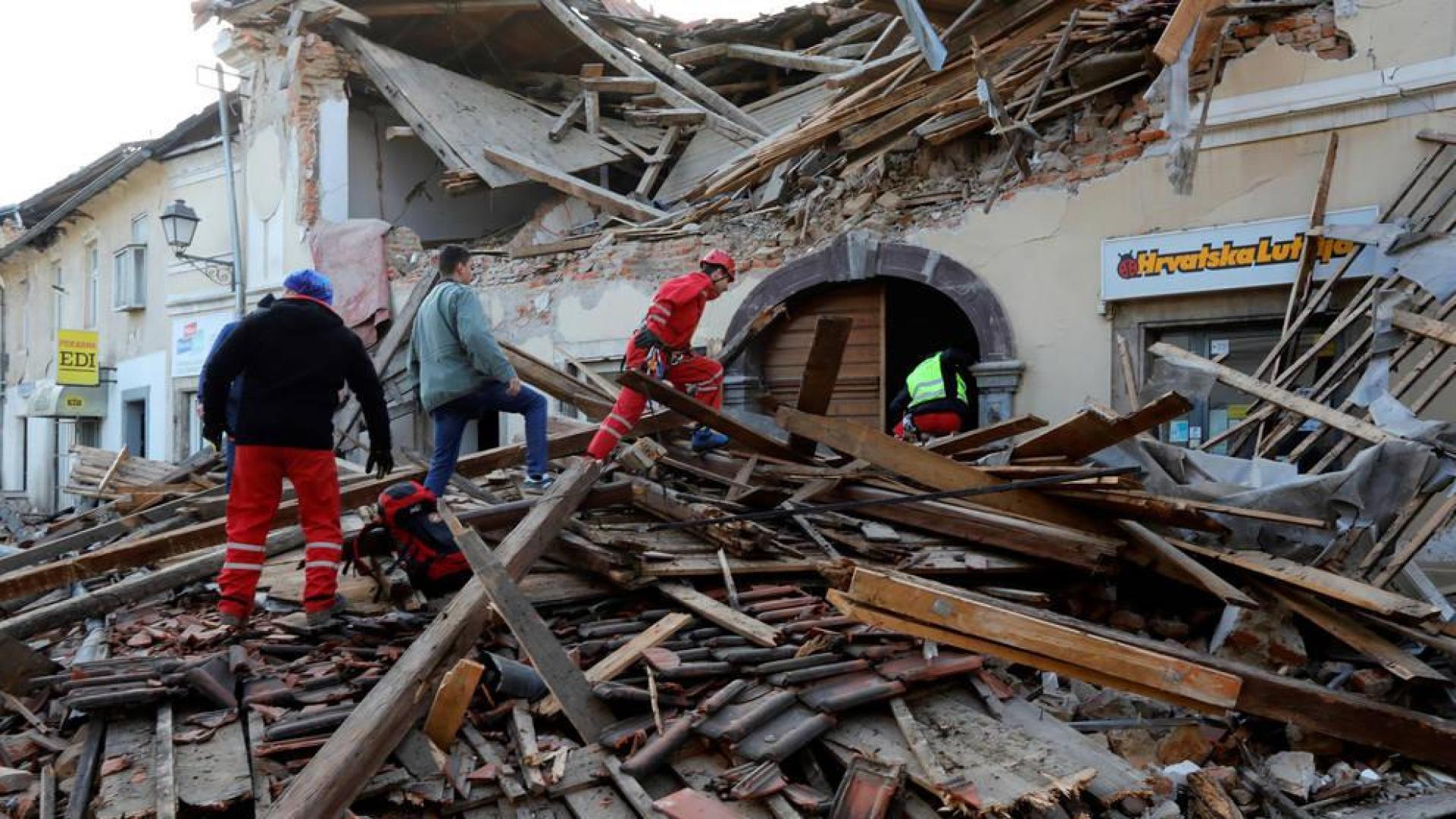 Personal de rescate camina entre los escombros de un edificio afectado por el terremoto en Petrinja (Croacia)