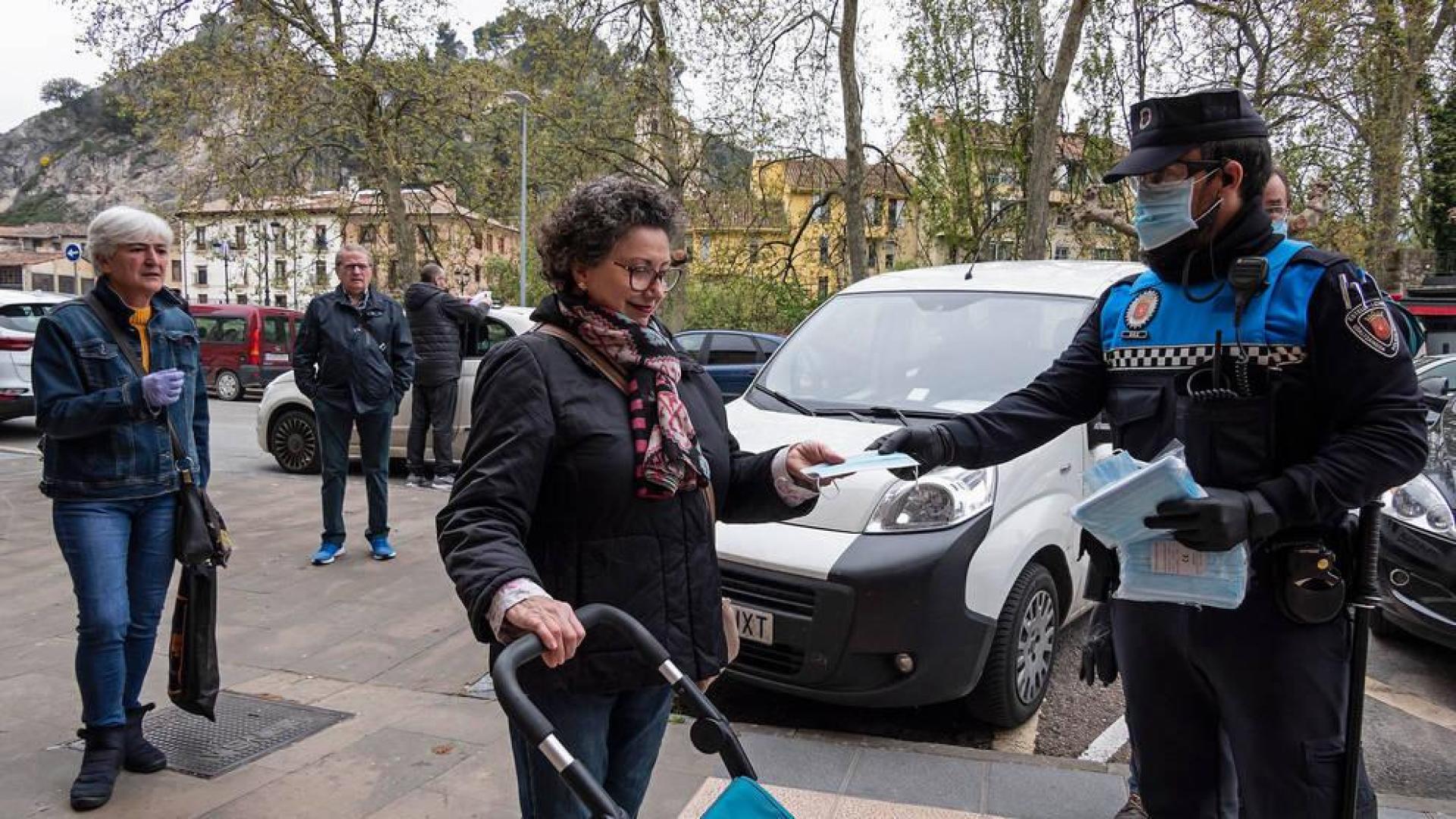 Un Policía Municipal de Estella repartiendo mascarillas