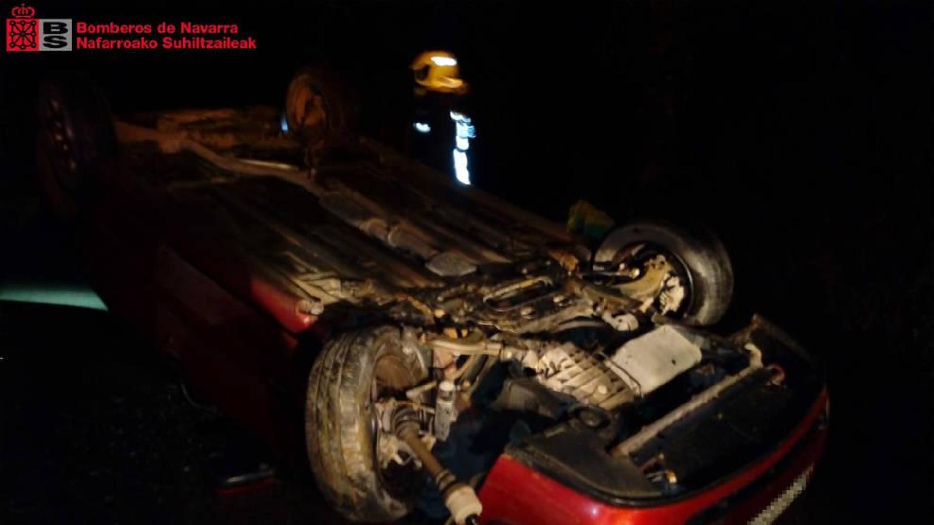 Los bomberos, junto al vehículo accidentado.